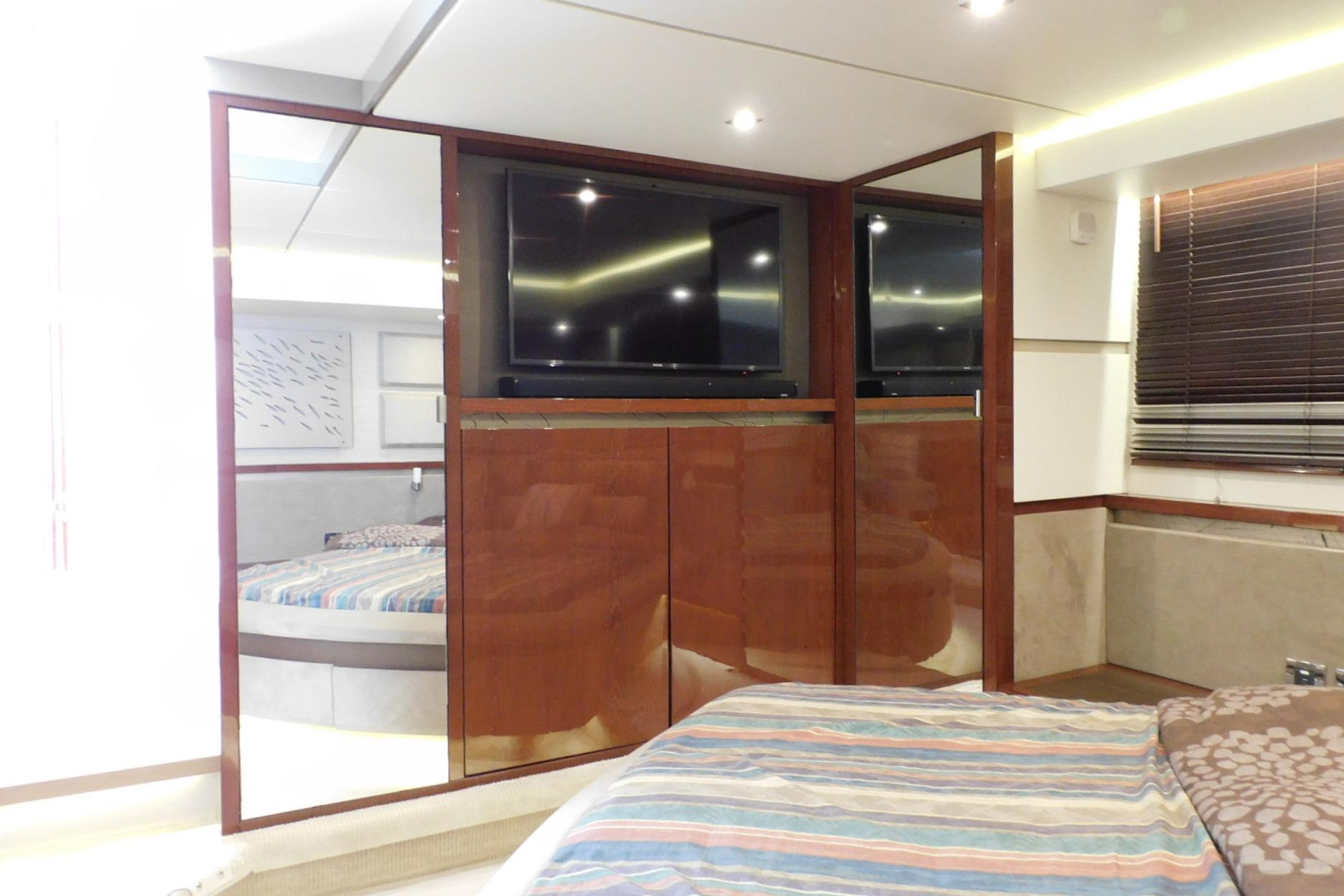 Luxurious interior of 2019 Sea Ray L550 yacht with modern wood paneling and TV.