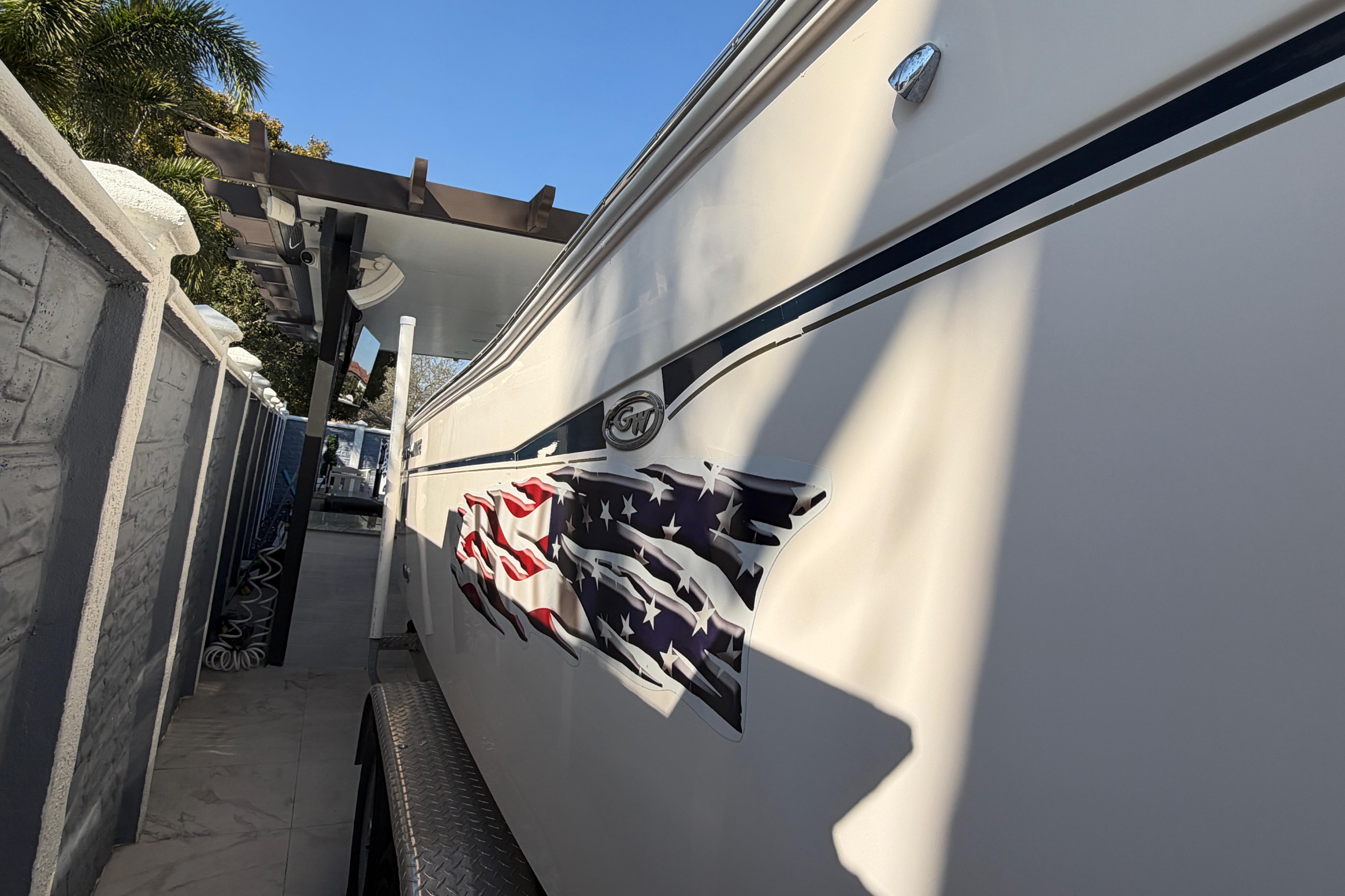 2004 Grady White 273 boat with American flag decal, parked under a canopy.