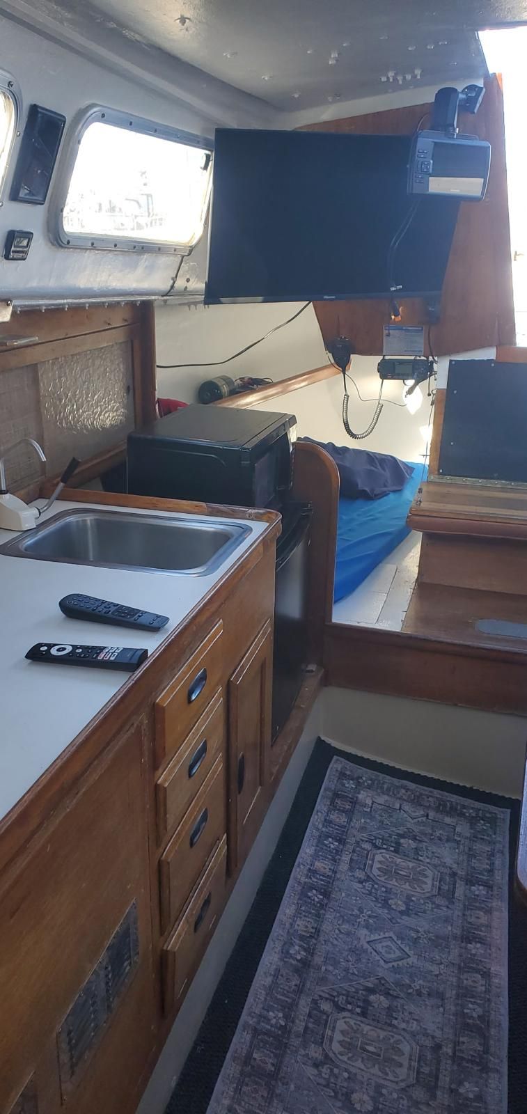 Interior of a Cal 29 yacht with a sink, cabinets, and a television.