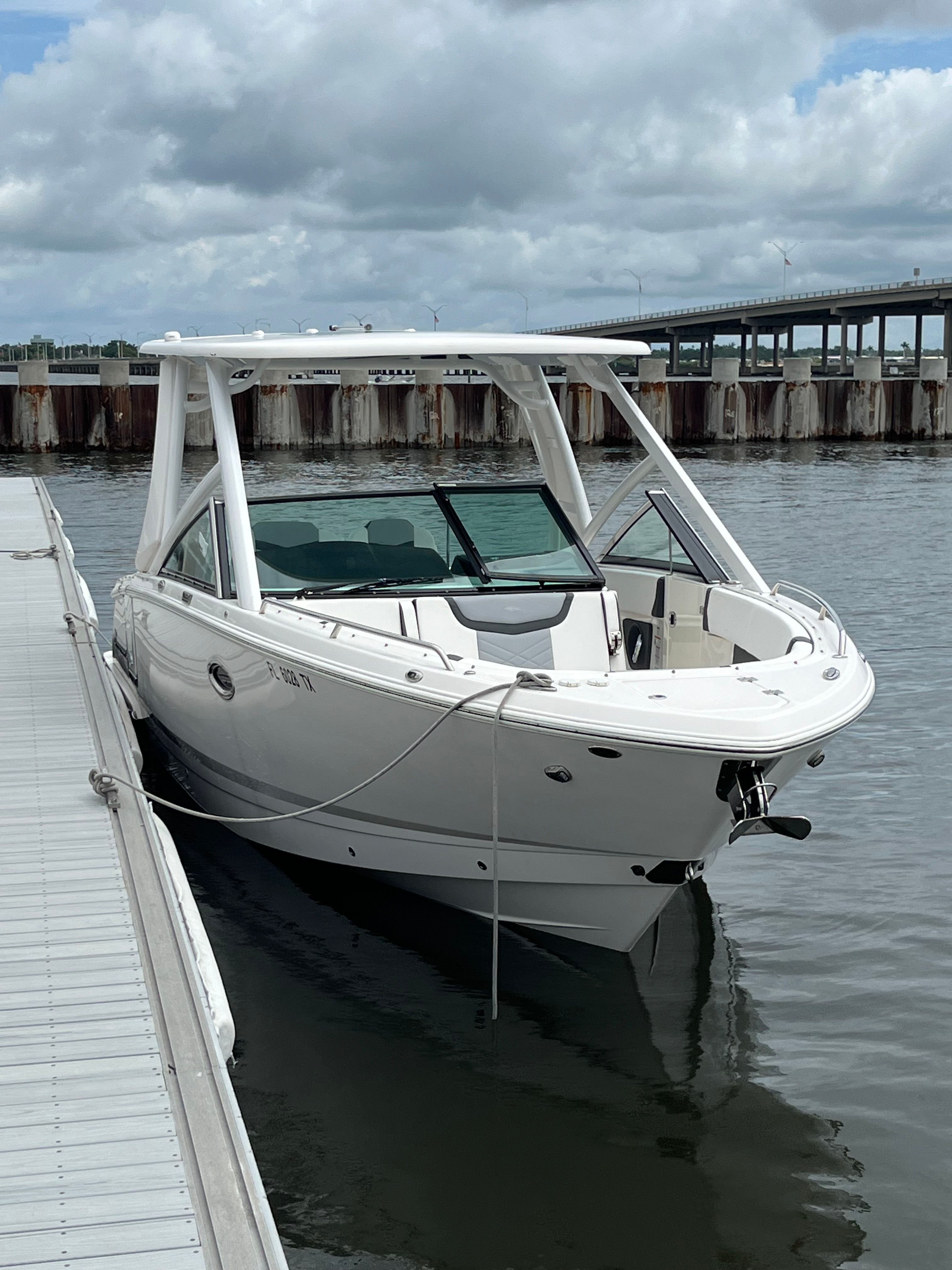 A 2023 Chaparral 28 OSX boat docked. It features a sleek design and white exterior.
