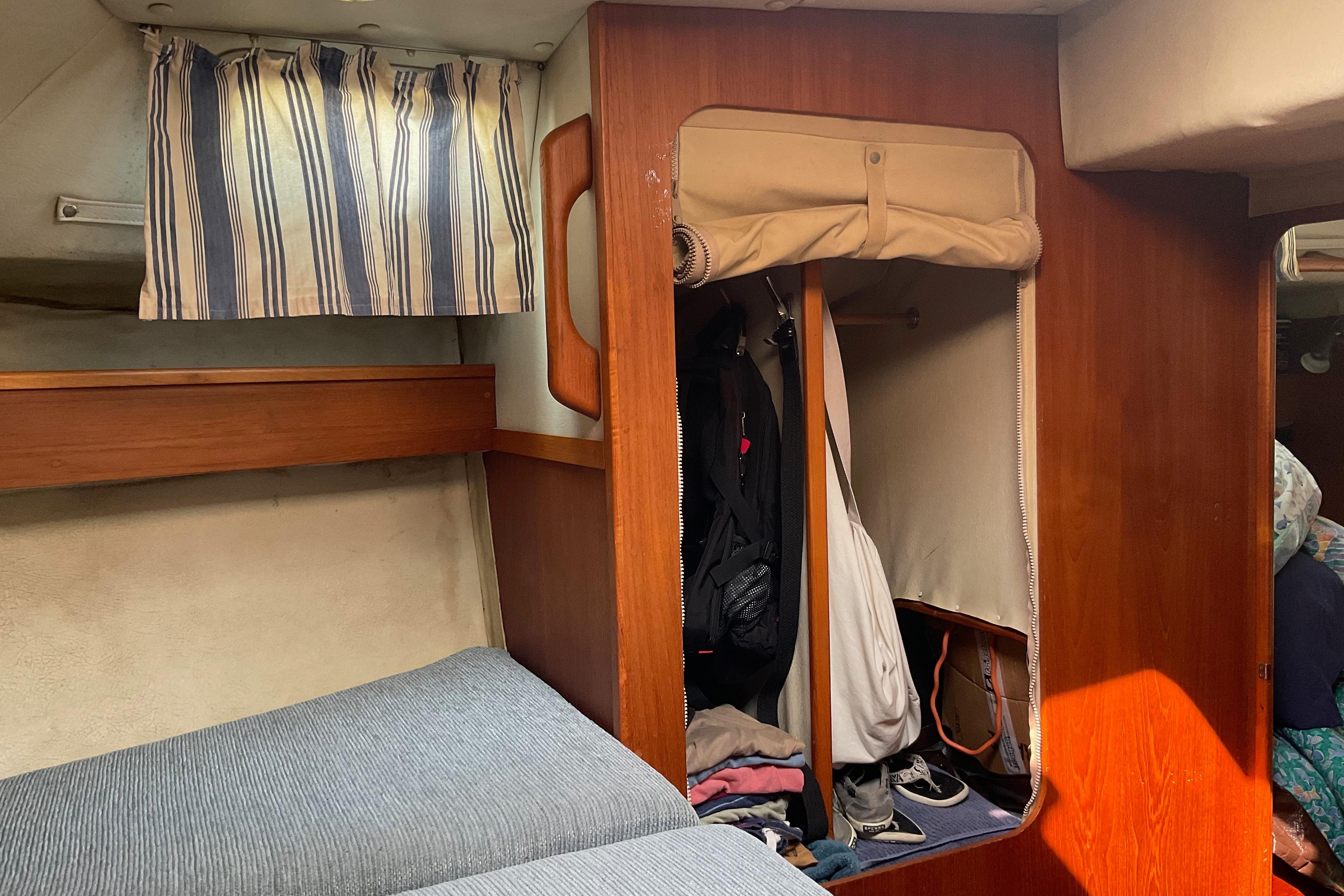 Interior cabin of 1988 Westerly Corsair 36 sailboat with striped curtains and storage area.