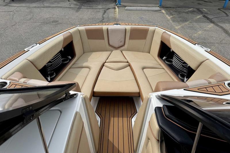 2019 Nautique Super Air Nautique G23 boat interior with tan seating and wood flooring.