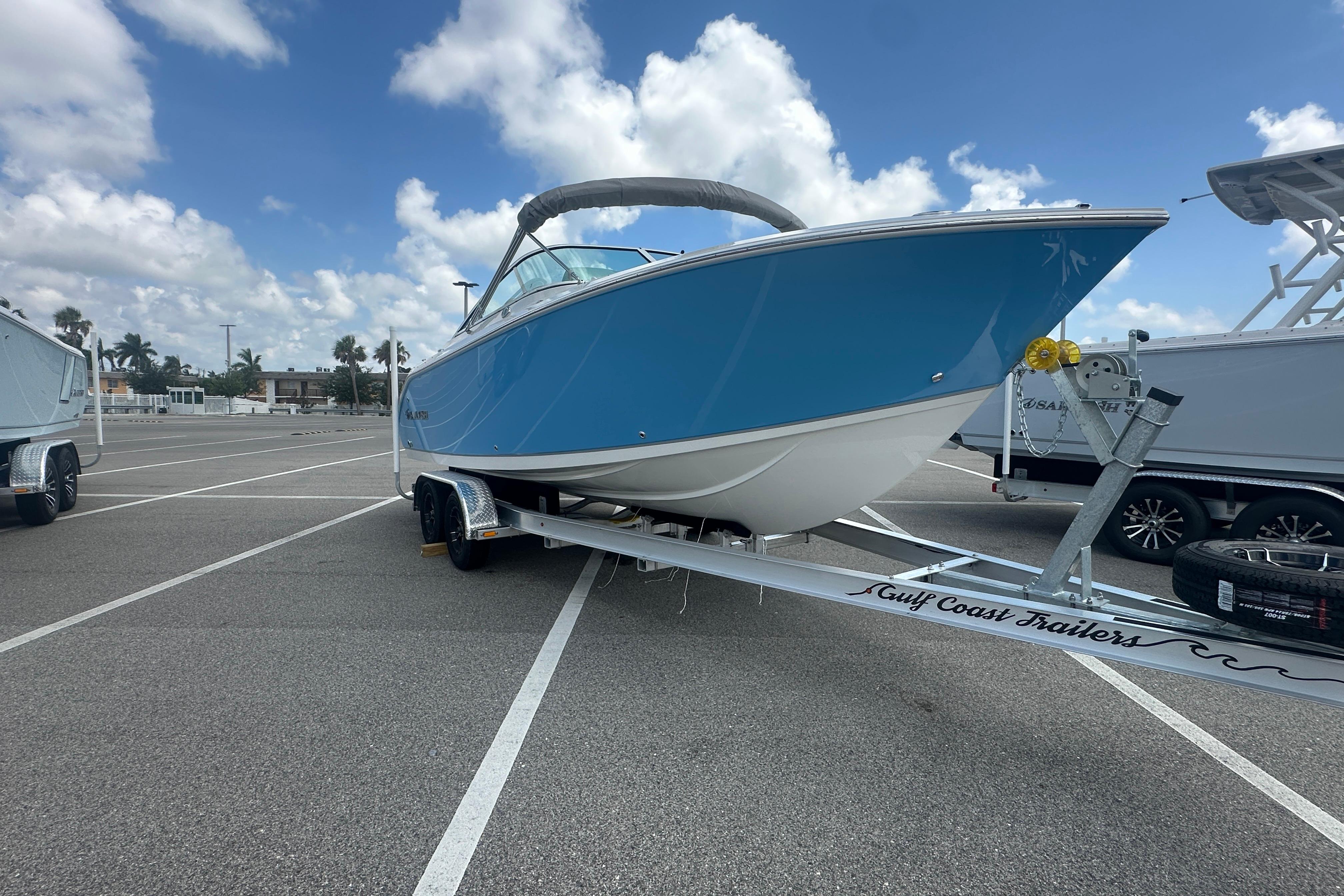 2026 Sailfish 226 DC boat on trailer in parking lot under blue sky.
