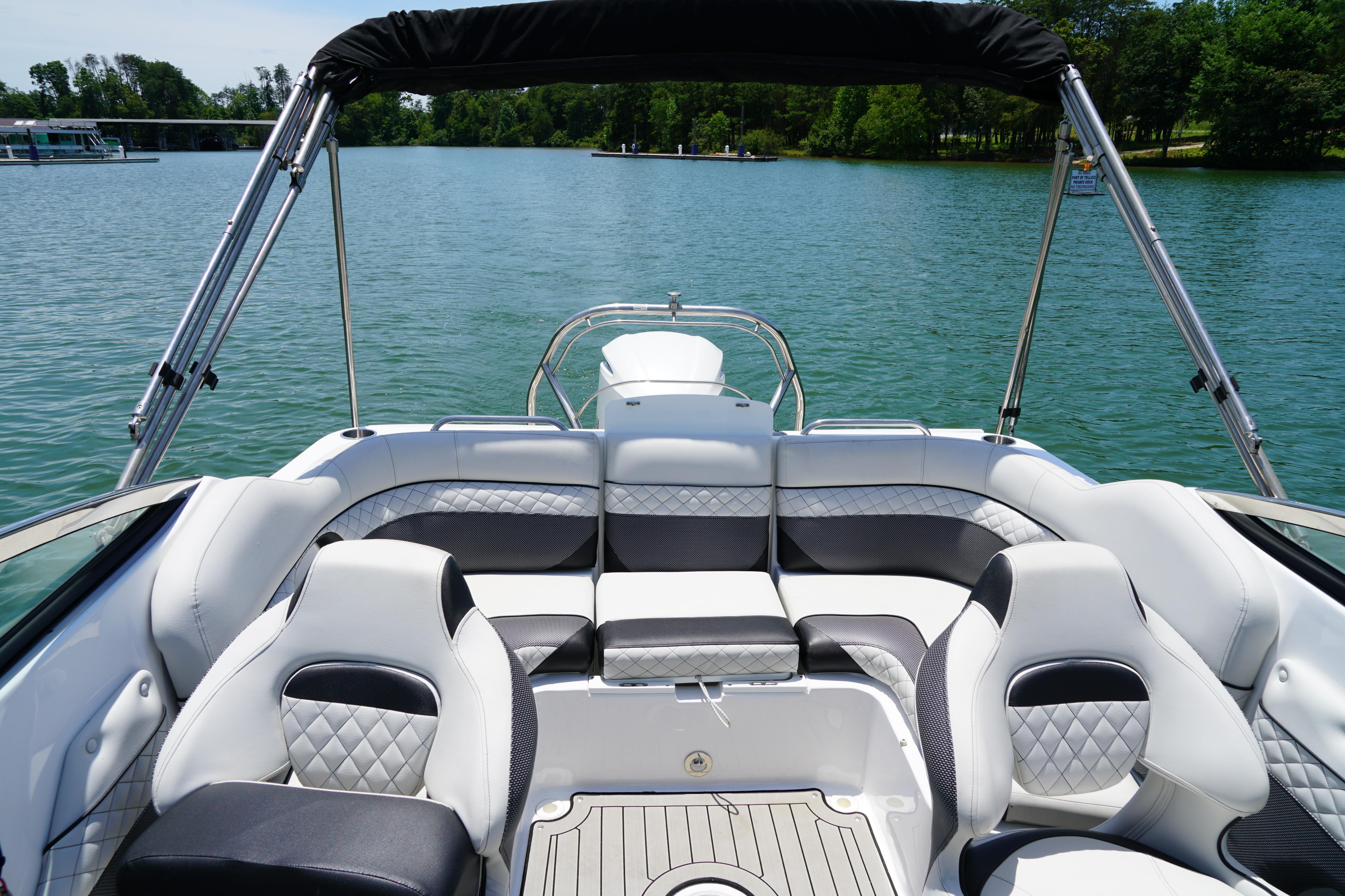 2020 Hurricane SunDeck 2486 OB boat interior with plush seating on a serene lake.