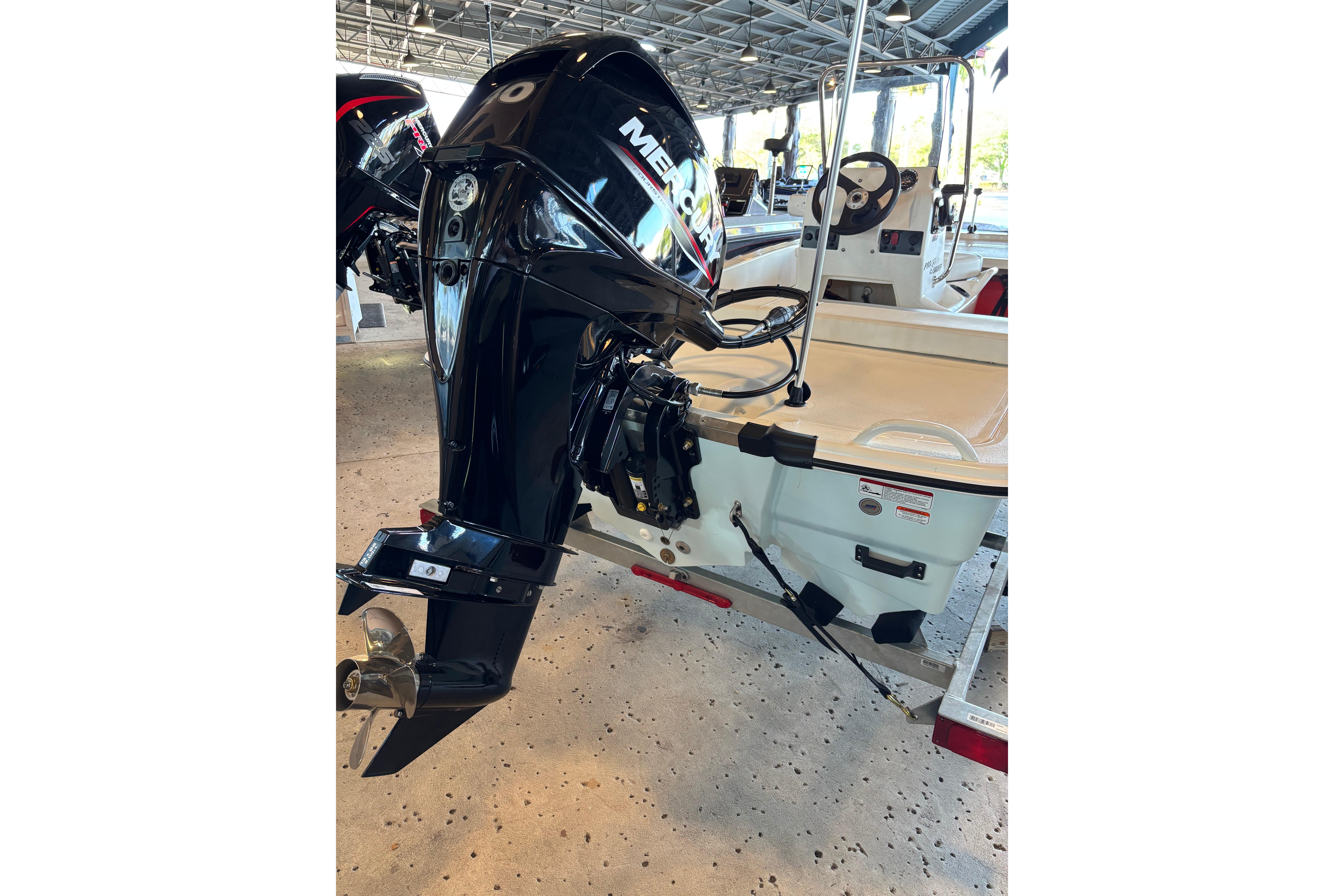 2026 Mako Pro Skiff 13 CC with Mercury outboard motor in a covered marina.