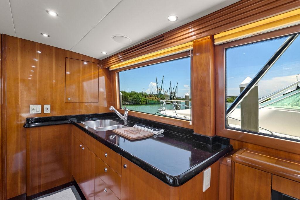 Luxurious kitchen interior of 2003 Hatteras 60 Convertible yacht with scenic window view.
