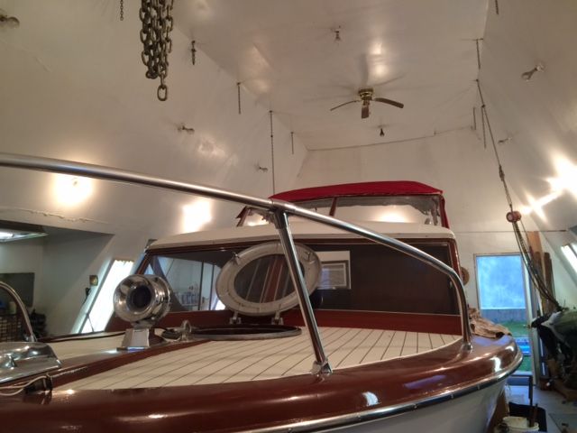A classic 1959 Owens Flagship boat in a warehouse. It features an elegant wooden deck.