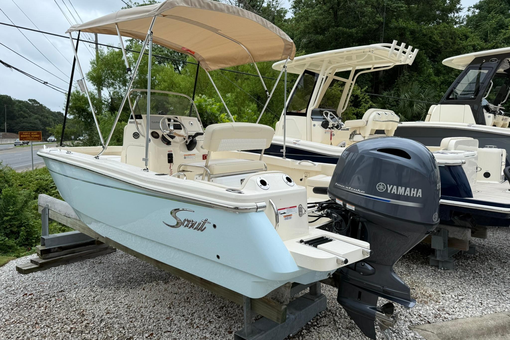 2027 Scout 188 Sportfish boat with Yamaha engine, parked outdoors on gravel.