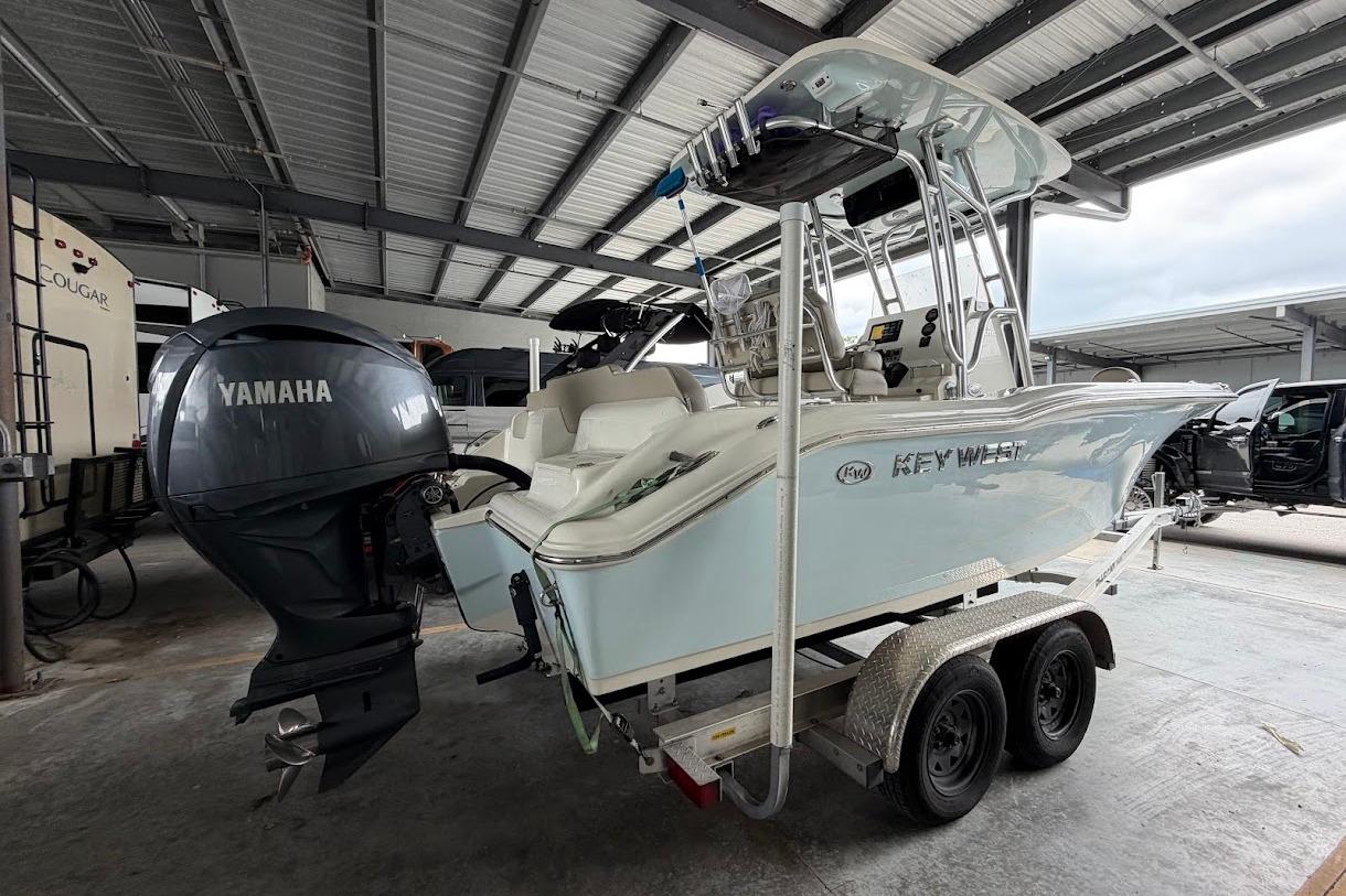 2024 Key West 219 FS boat on trailer with Yamaha outboard motor in covered storage.