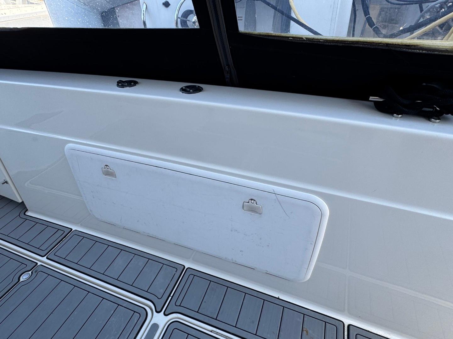 2003 Meridian 381 Sedan boat interior with storage compartment and non-slip flooring.