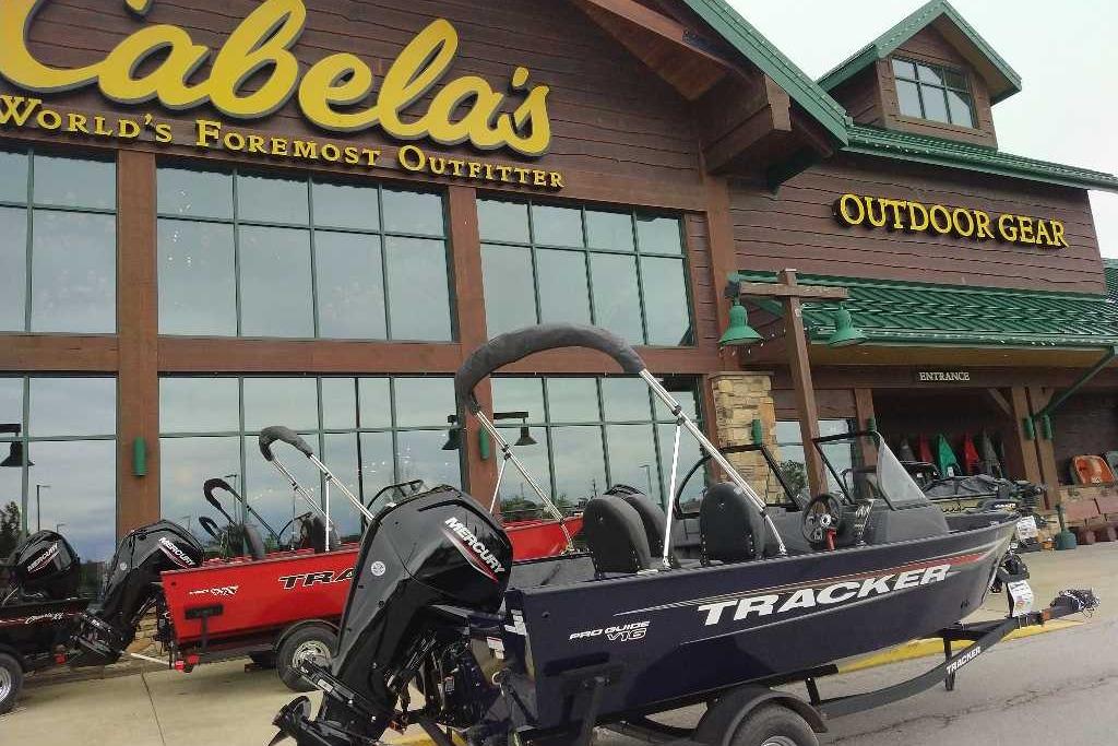 2026 Tracker Pro Guide V-16 WT boat displayed outside Cabela's outdoor gear store.