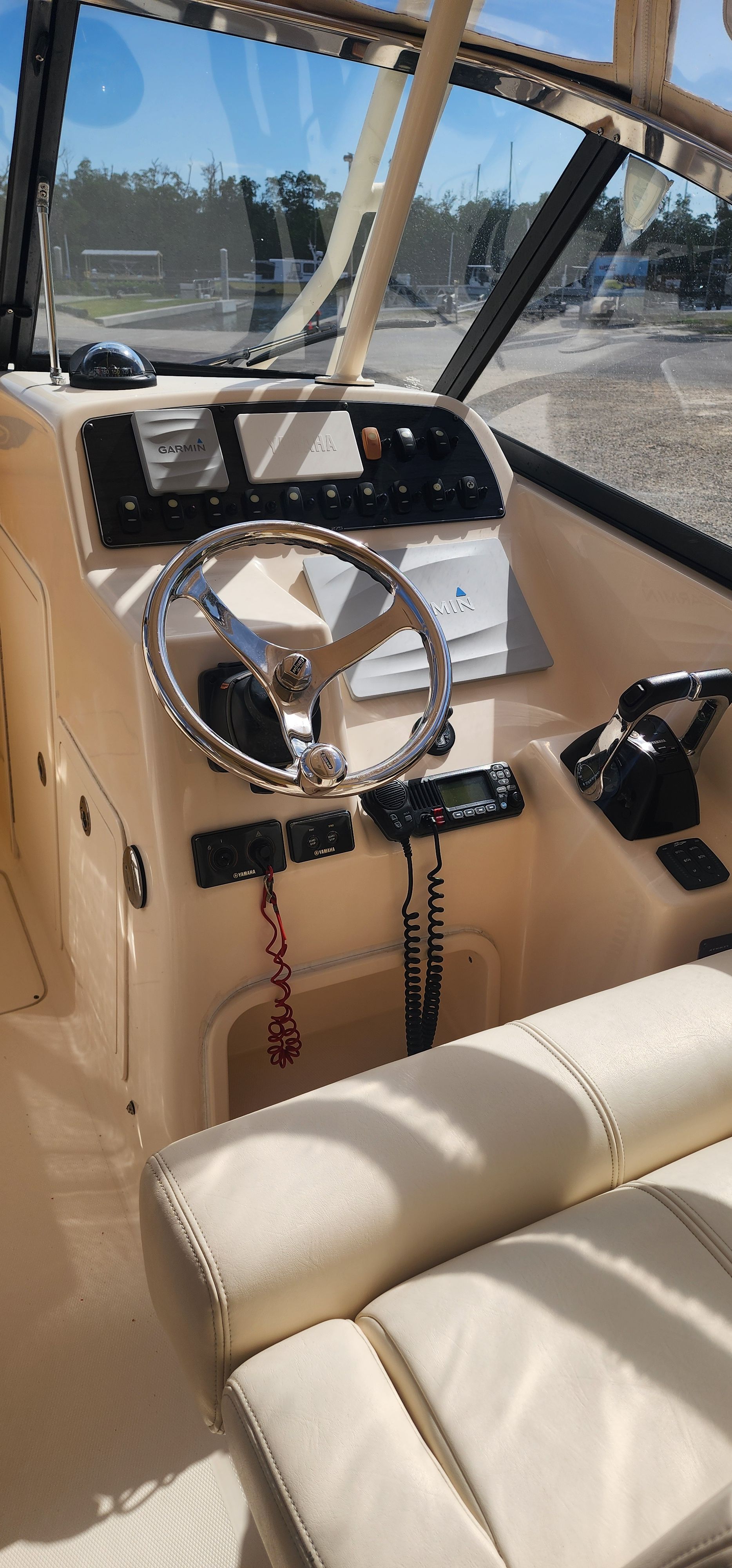 The image shows the helm of a 2015 Grady-White Freedom 275 boat with a sleek steering wheel.