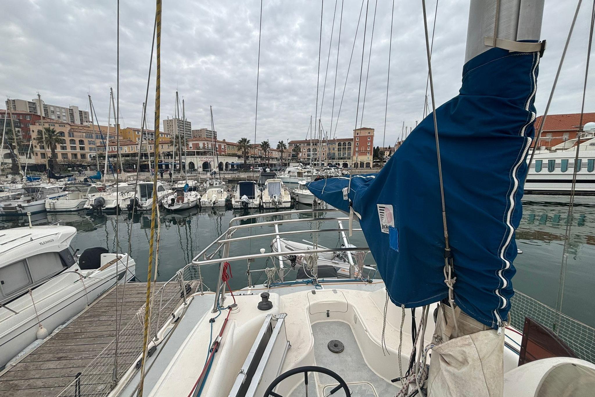 1998 Prout 38 sailboat docked in a marina with surrounding boats and buildings.