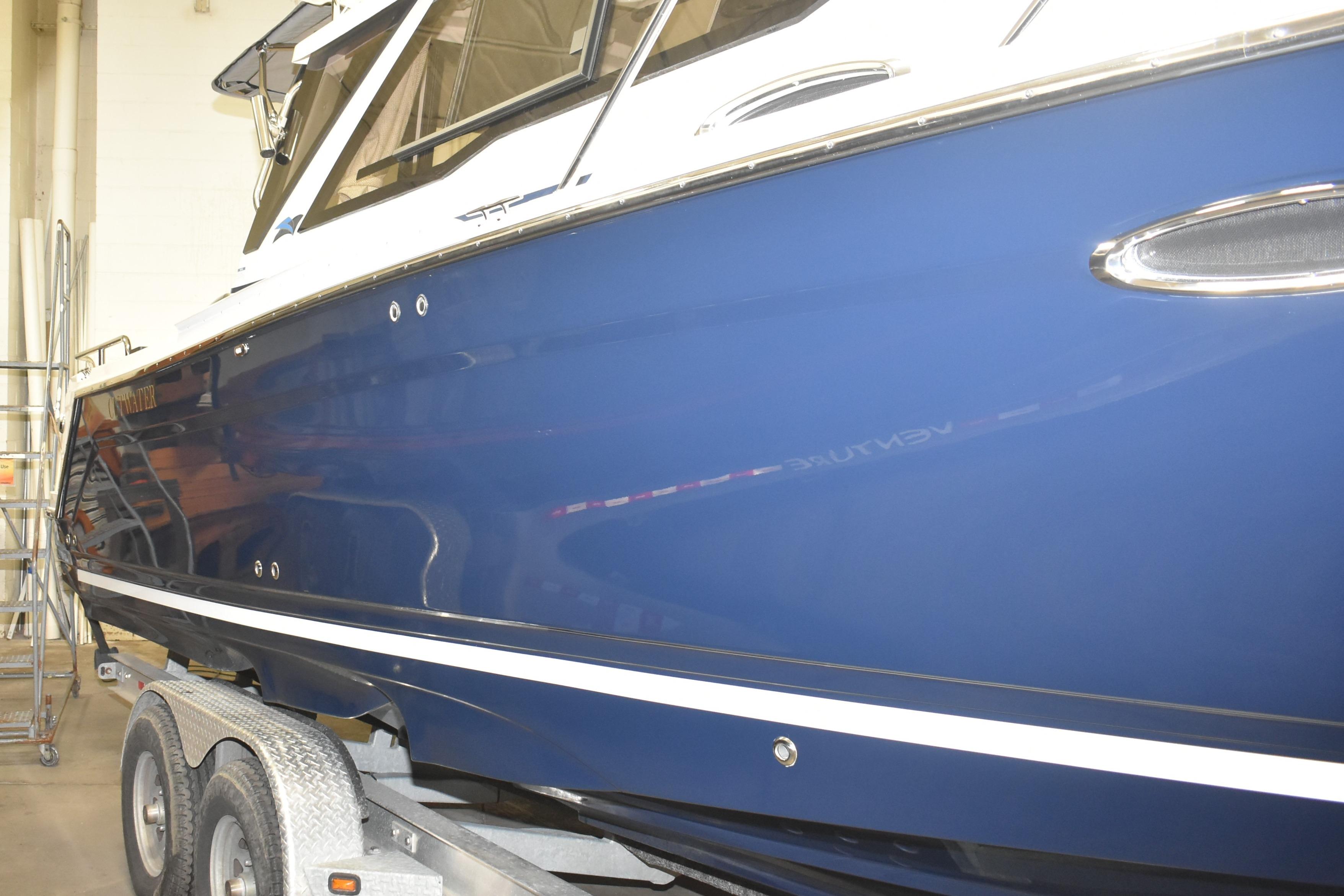 2026 Cutwater C-248 Coupe boat on trailer, blue hull, indoor setting.