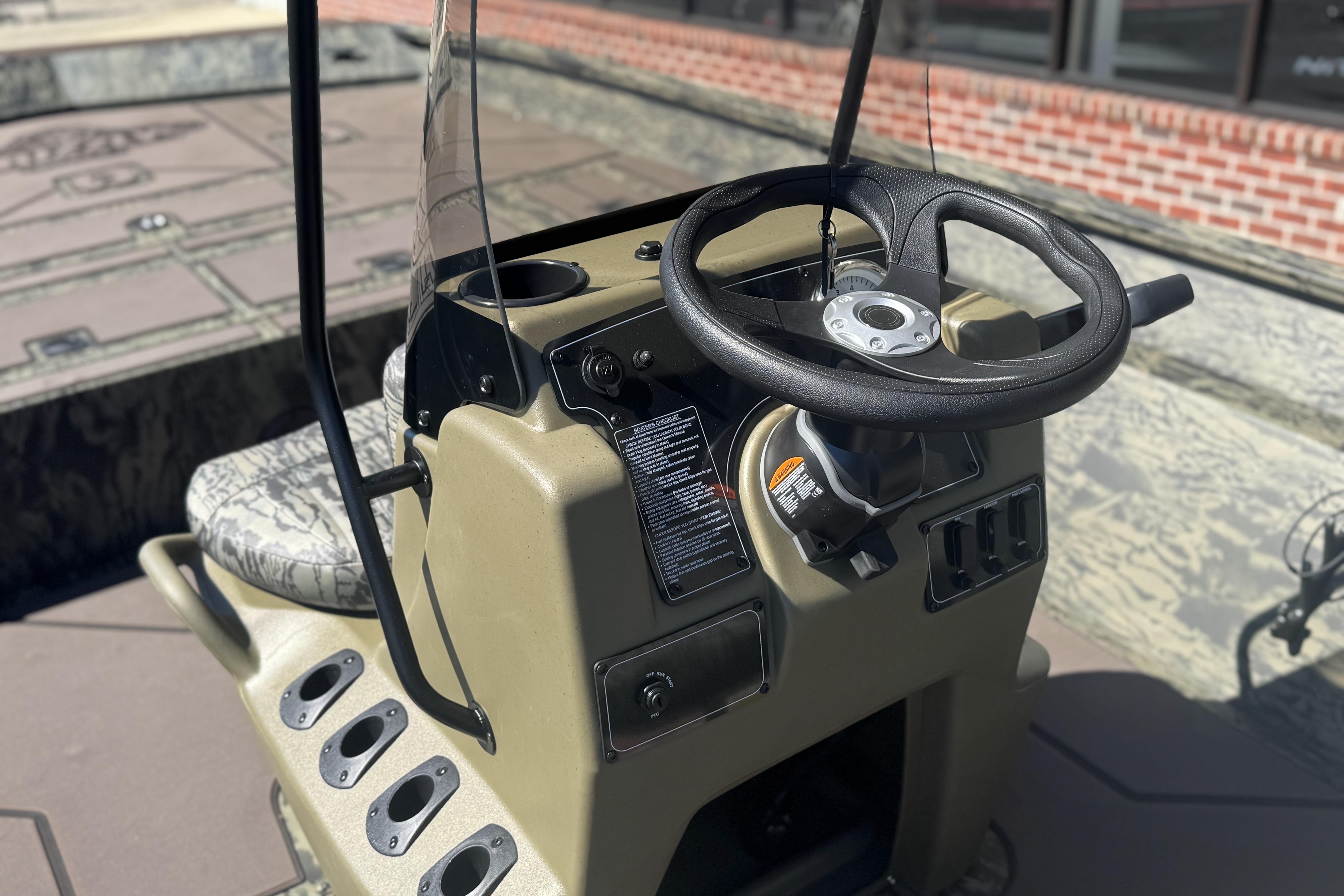 2026 Tracker Grizzly 2072 CC boat console with steering wheel and controls.