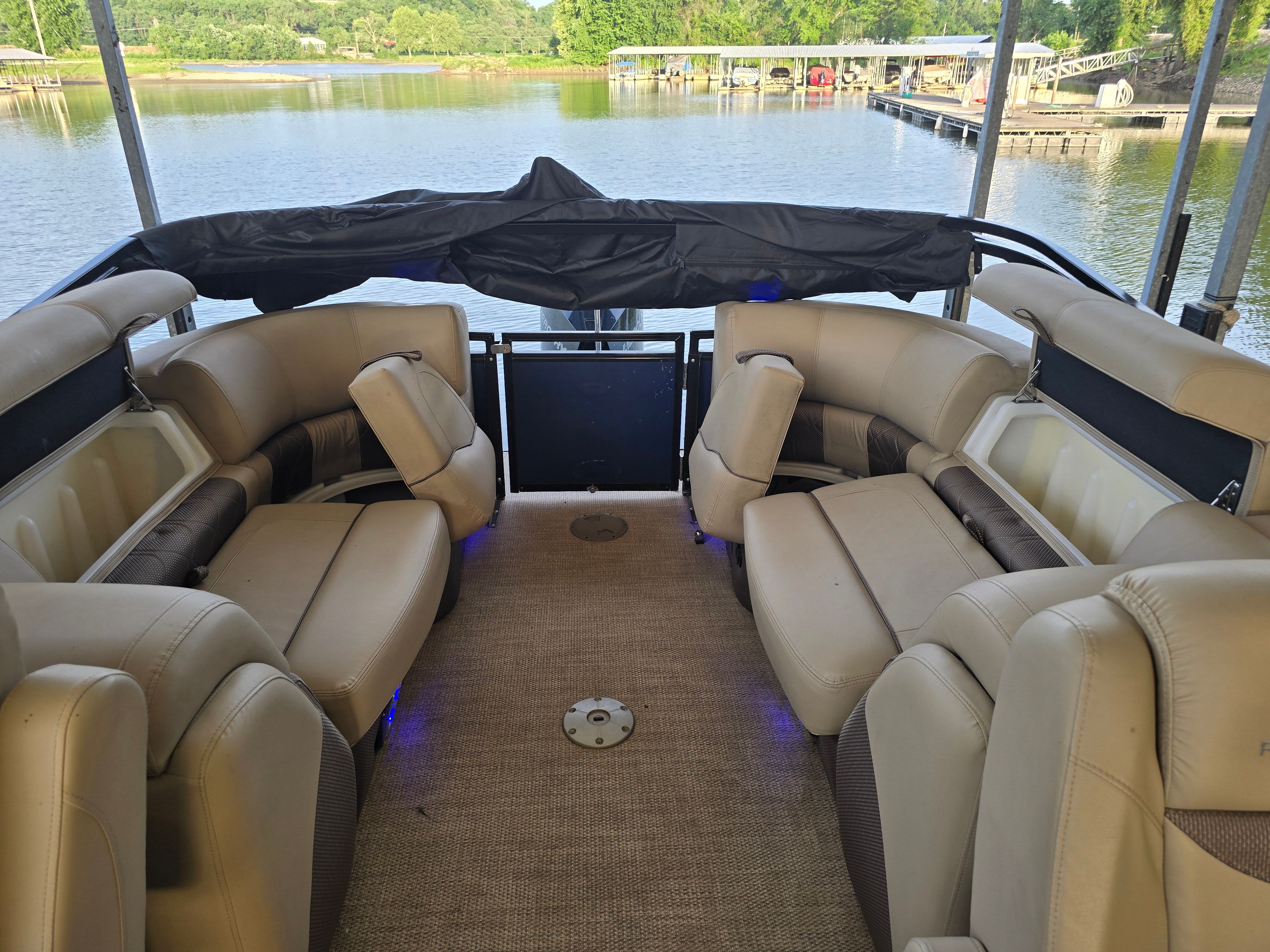 The image shows the interior of a 2021 Regency 230 LE3 boat with beige seating.