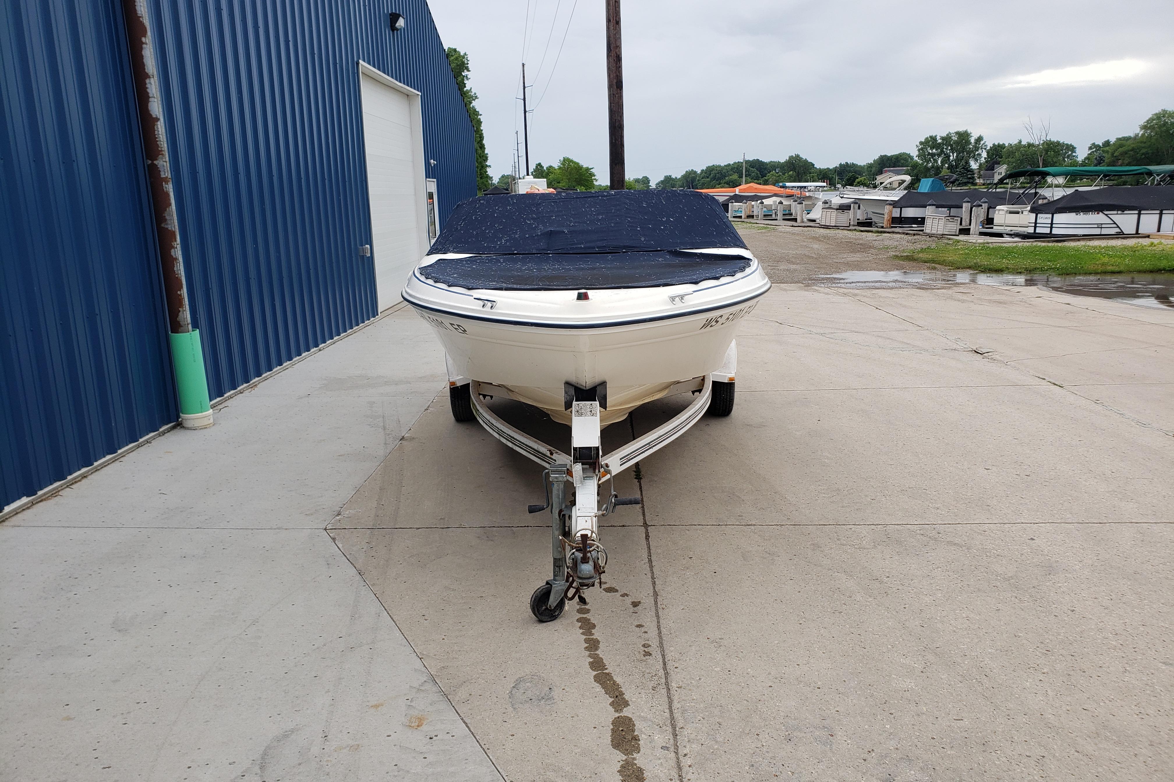 1998 Sea Ray 180 Bow Rider boat on trailer, parked near blue building.