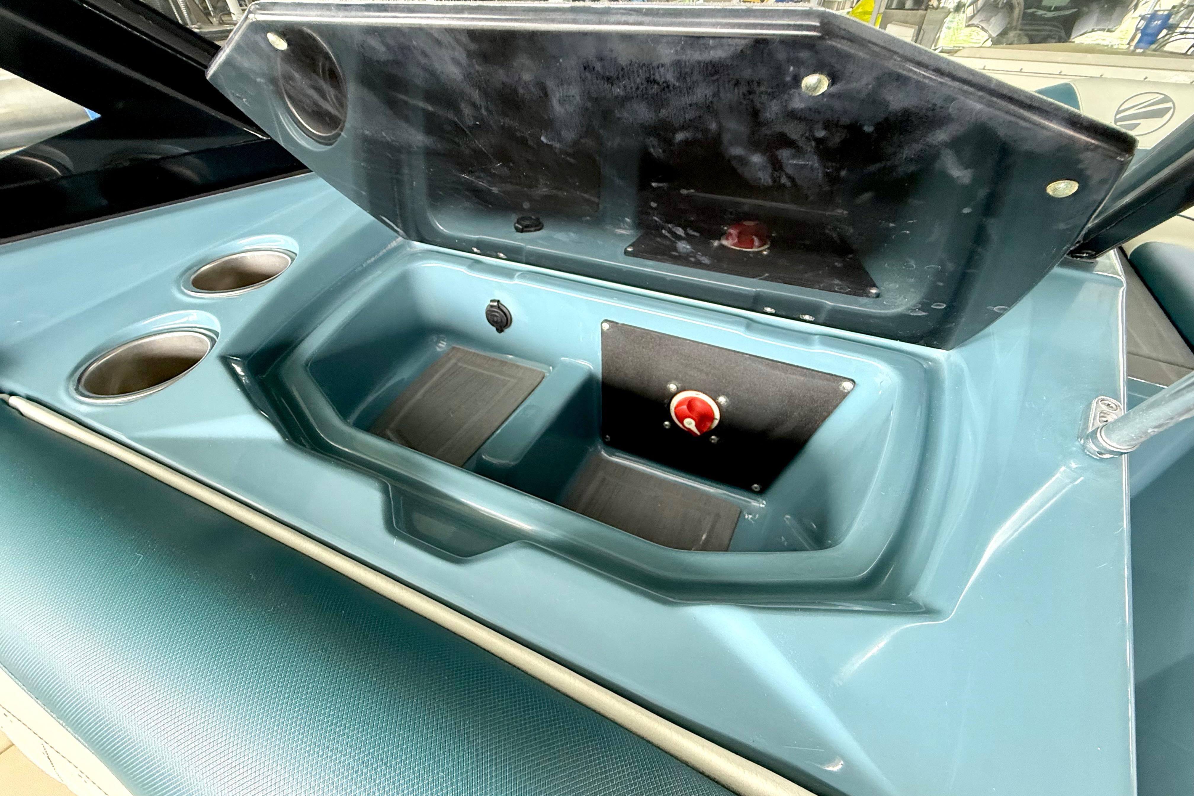 2021 Tige Z3 boat storage compartment with open lid and cup holders.