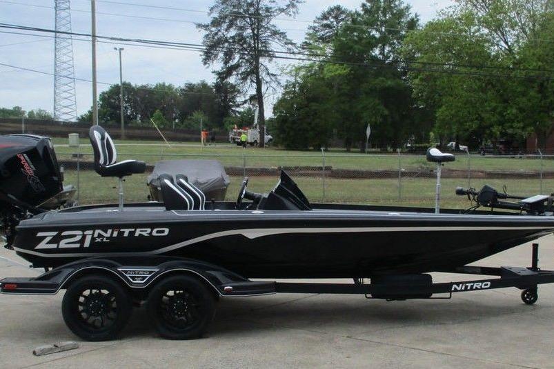 Black Tracker Pro Guide V-16 WT boat on trailer, parked outdoors, 2026 model.
