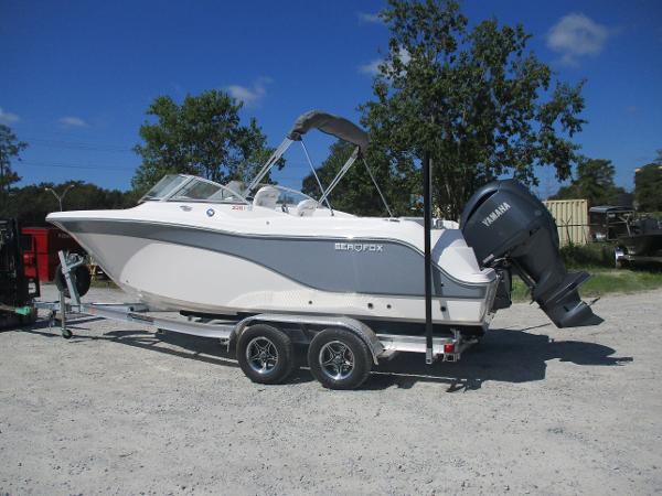 2025 Sea Fox 228 Traveler boat on trailer, parked outdoors.