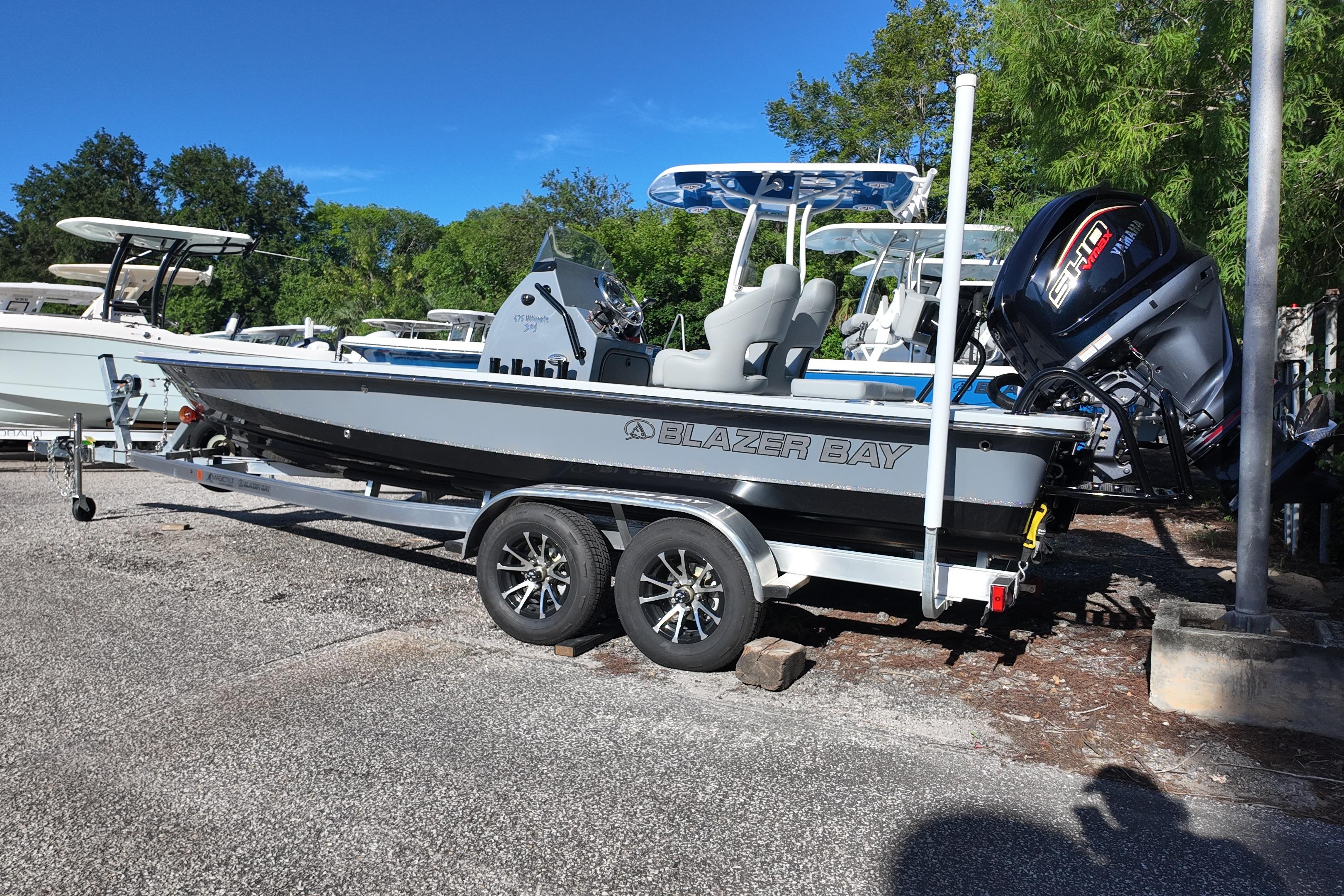 2026 Blazer Bay 675 Ultimate Bay boat on trailer, parked outdoors.