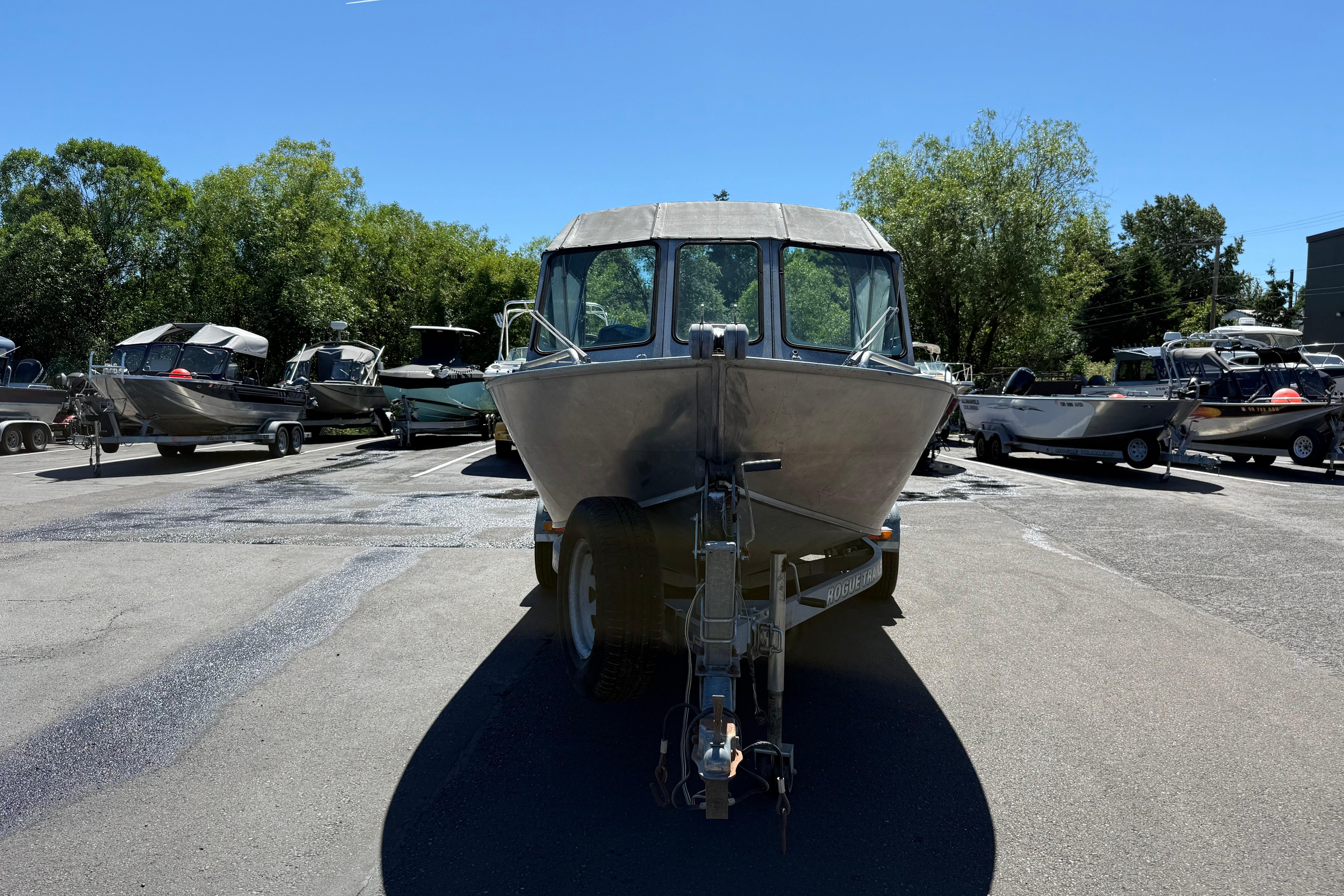 2004 Alumaweld Intruder Outboard 20 boat on trailer in sunny parking lot.