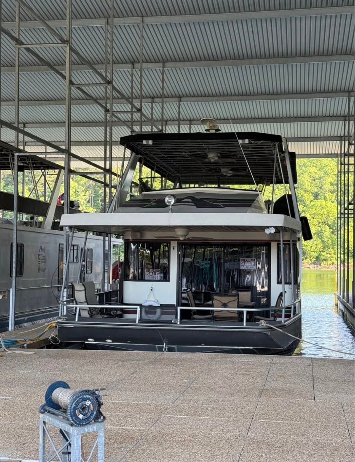 1998 Stardust Cruisers houseboat docked, covered, for sale.