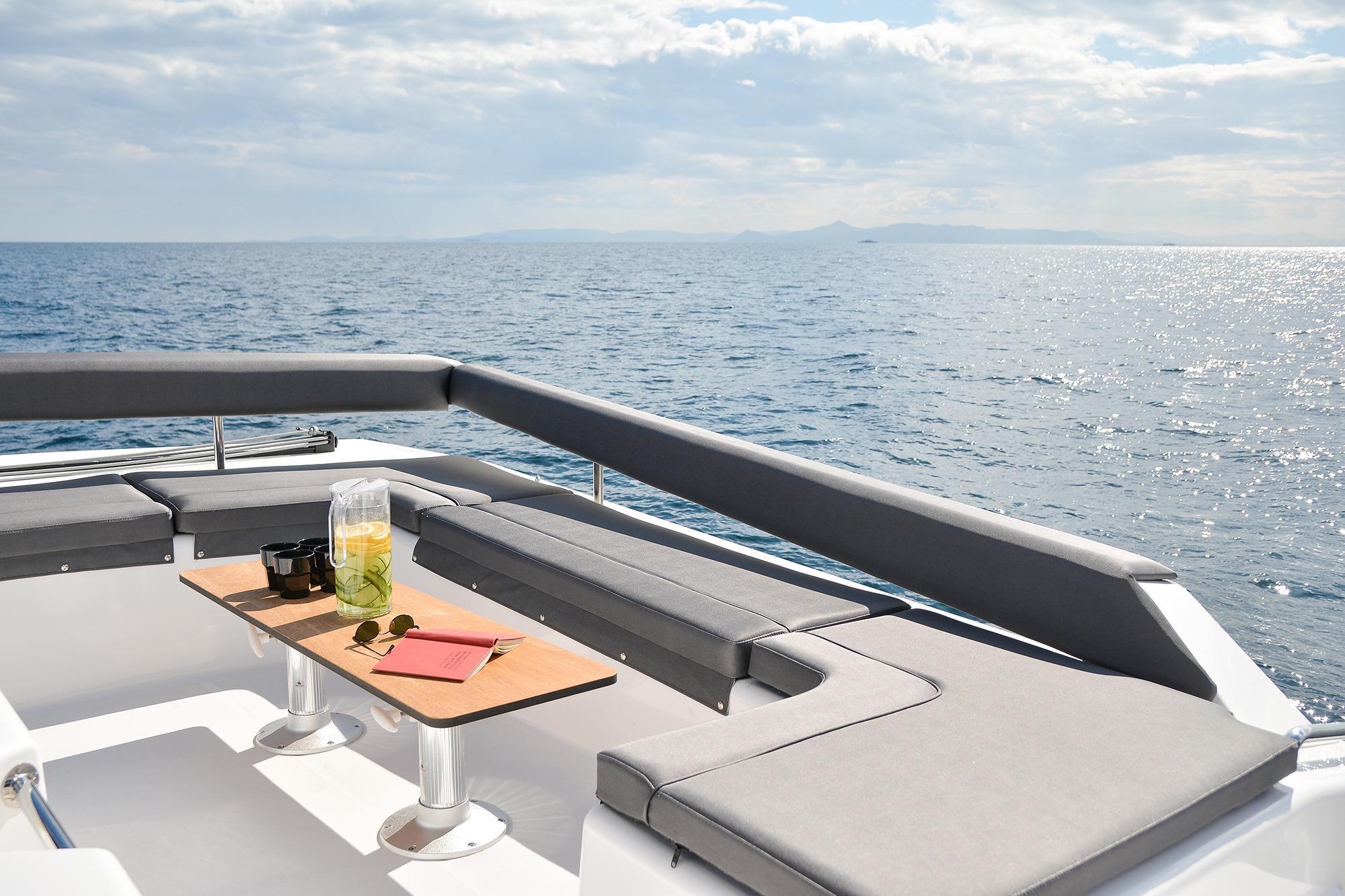Luxurious seating area on 2020 Dufour Catamarans 48, overlooking serene ocean waters.