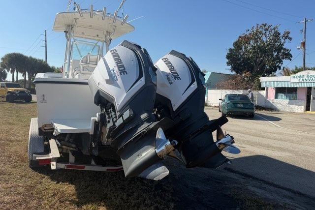 2002 Regulator 26 Forward Seating boat with twin Evinrude engines on a trailer.
