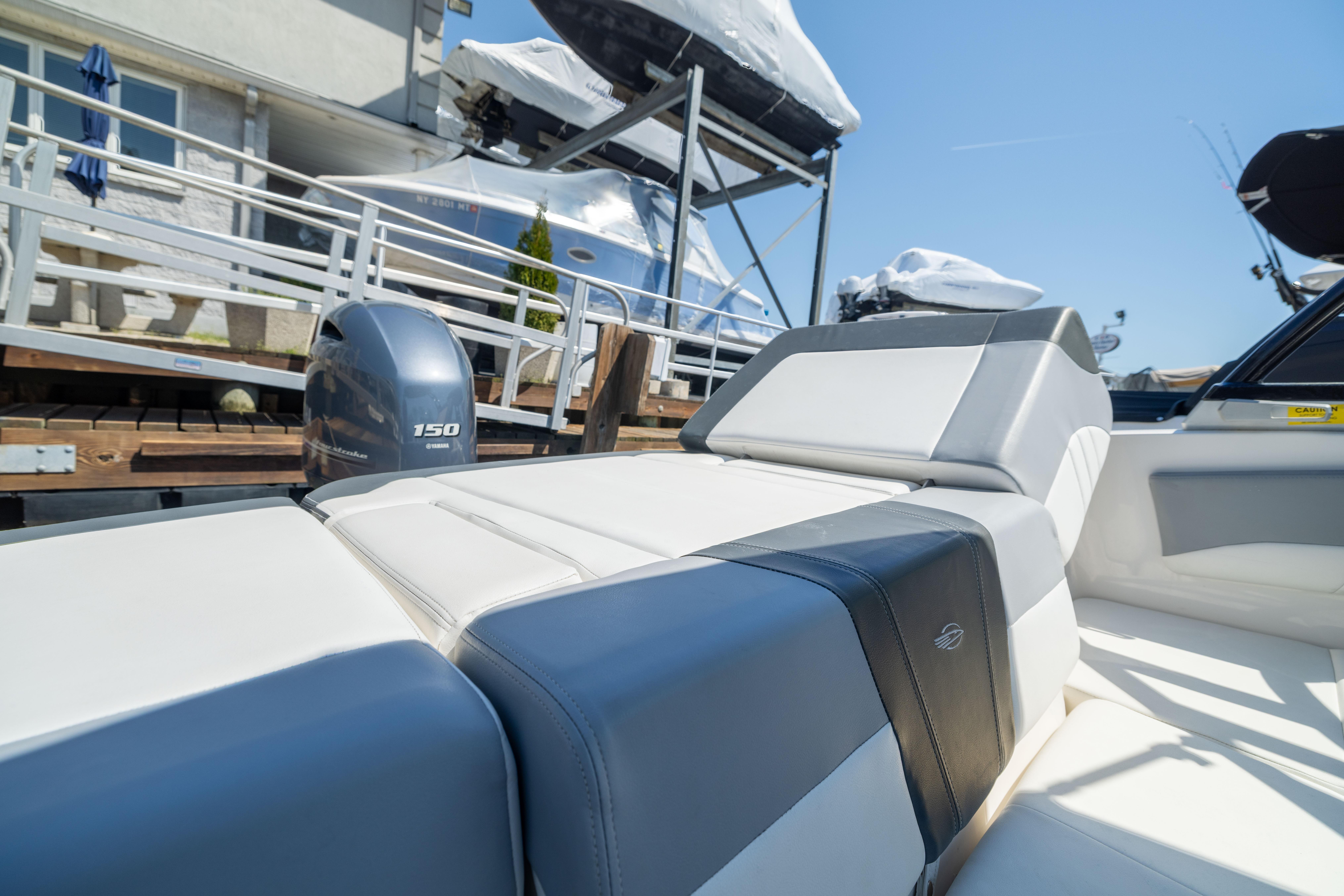 2022 Chaparral 21 SSi OB boat with Yamaha 150 engine, docked under clear blue sky.