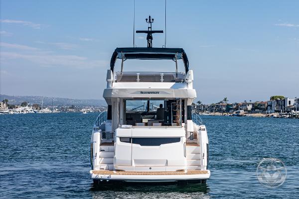 Sunseeker Manhattan 68 yacht, 2025 model, cruising on a serene waterway.