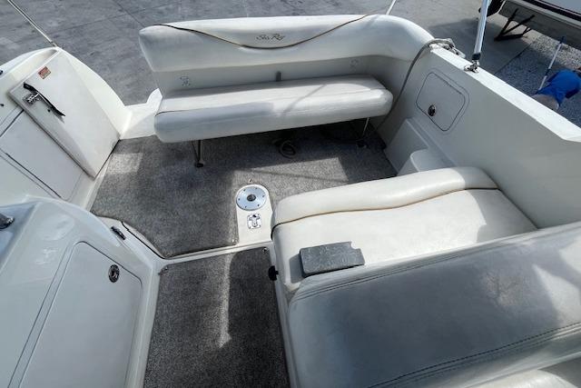 2003 Sea Ray 260 Sundancer boat interior with white seating and carpeted floor.