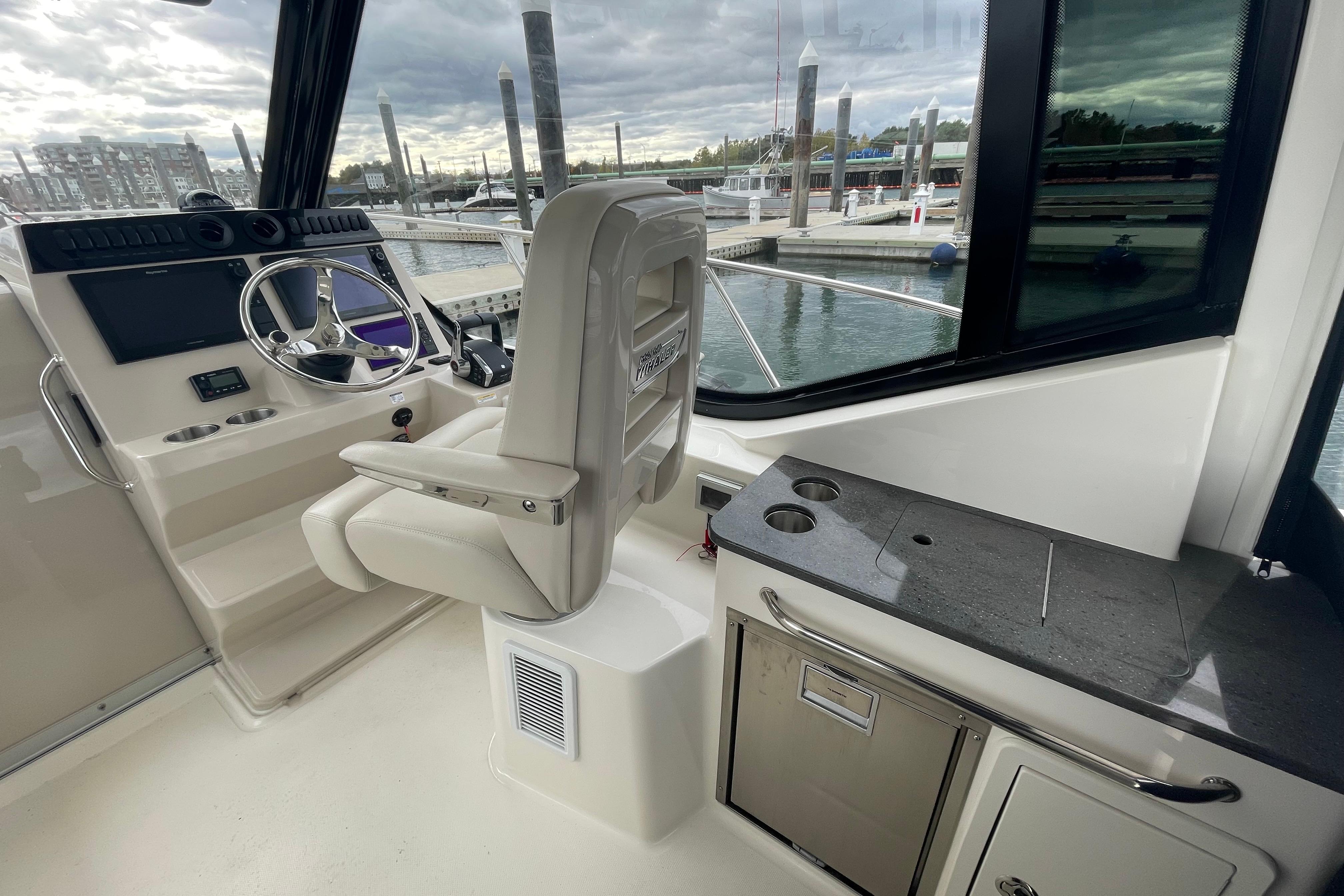 2023 Boston Whaler 325 Conquest helm with steering wheel and control panel.