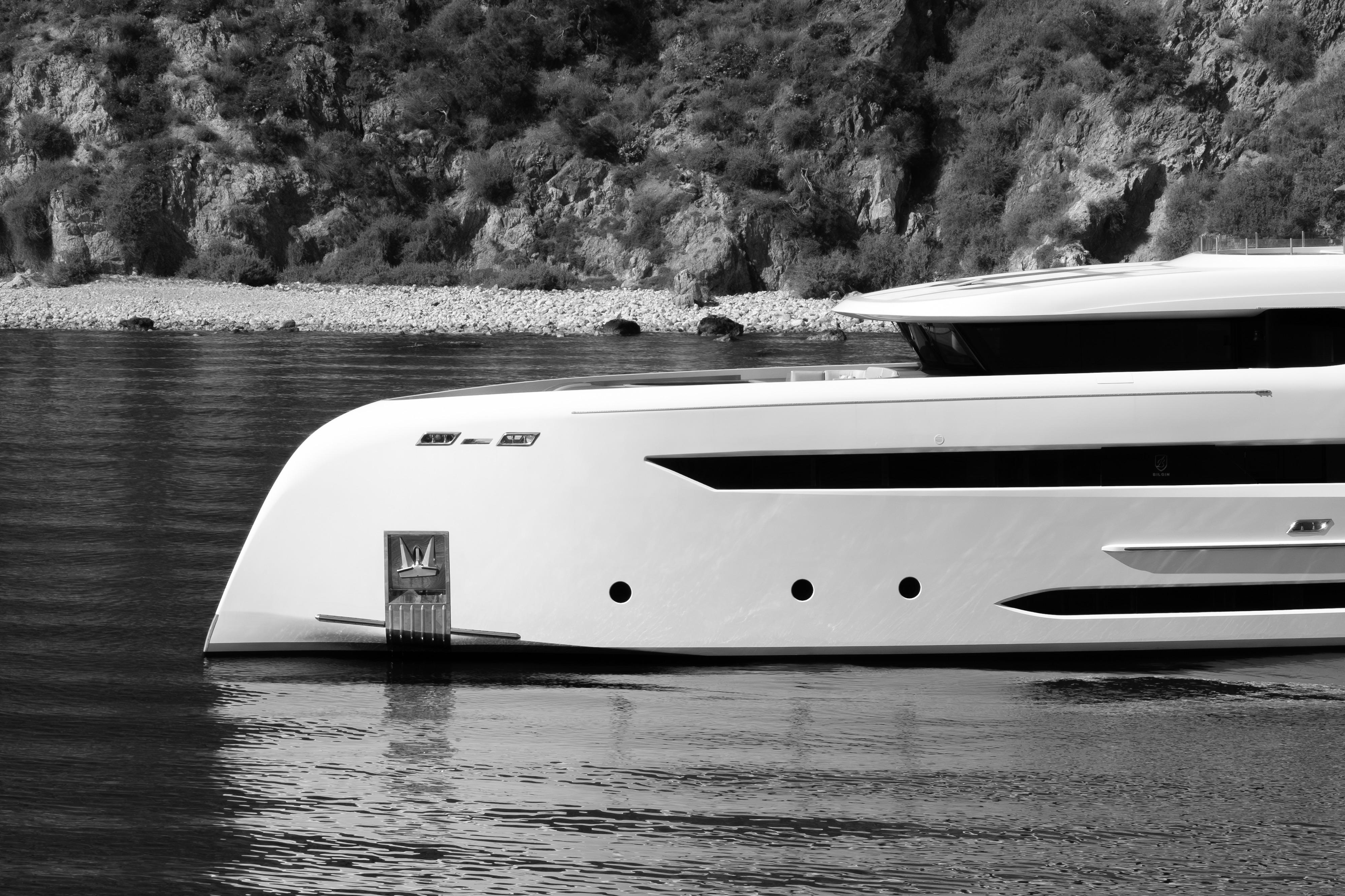 Bilgin 147 yacht from 2014, sleek design, anchored near rocky shoreline.