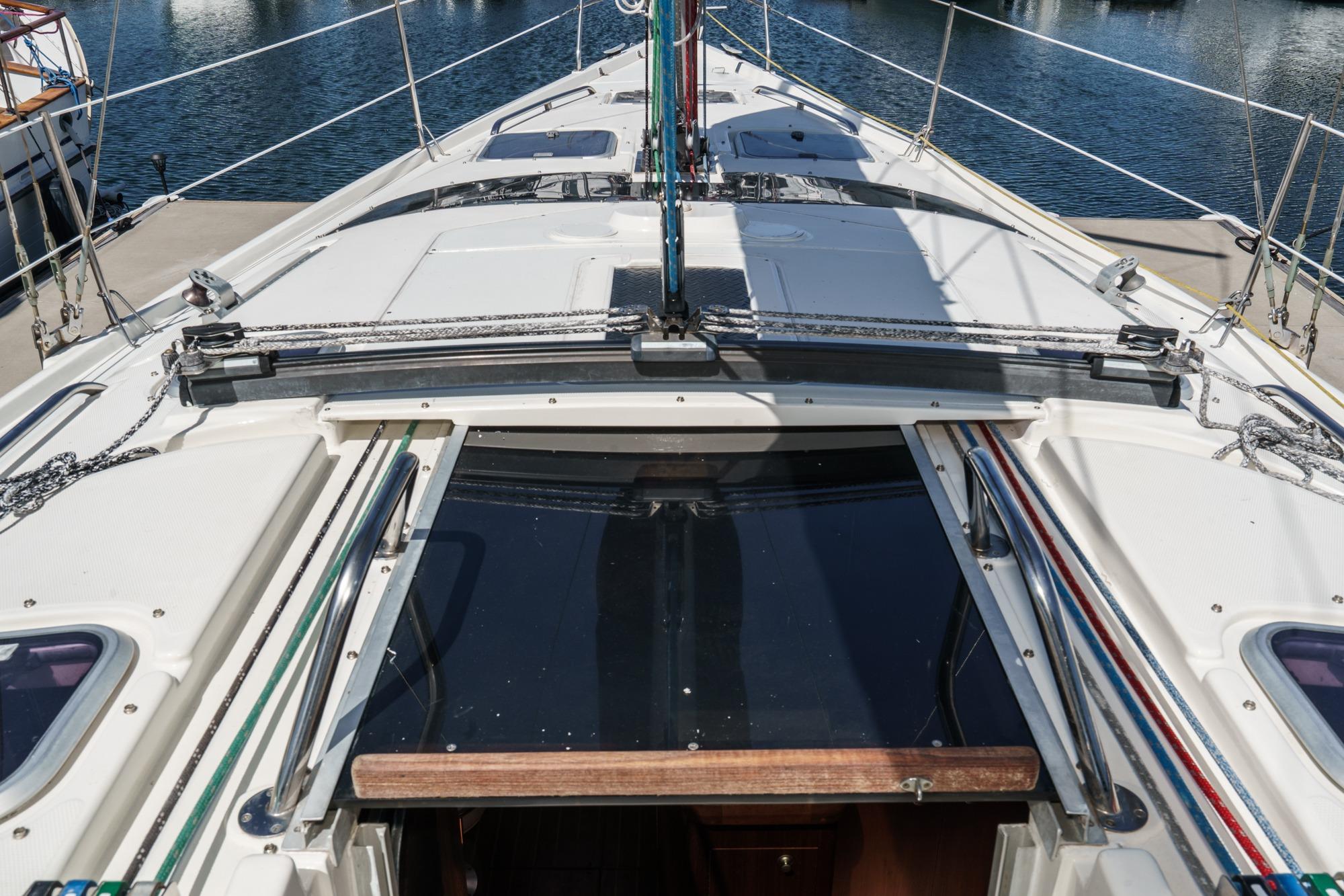 1996 Hunter 376 sailboat deck with open hatch, docked at marina.
