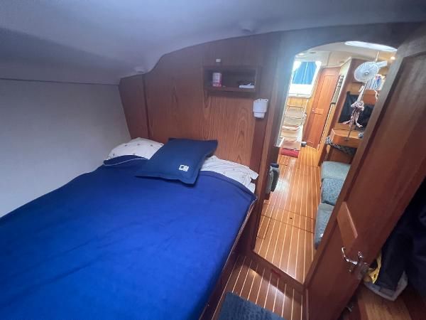 Interior of a 2000 Hunter 410 featuring a cozy bed and wooden furnishings.
