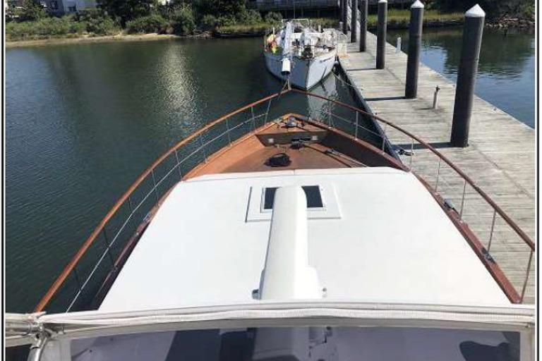 1974 Pacemaker Cockpit Motoryacht docked at a marina, viewed from the bow.