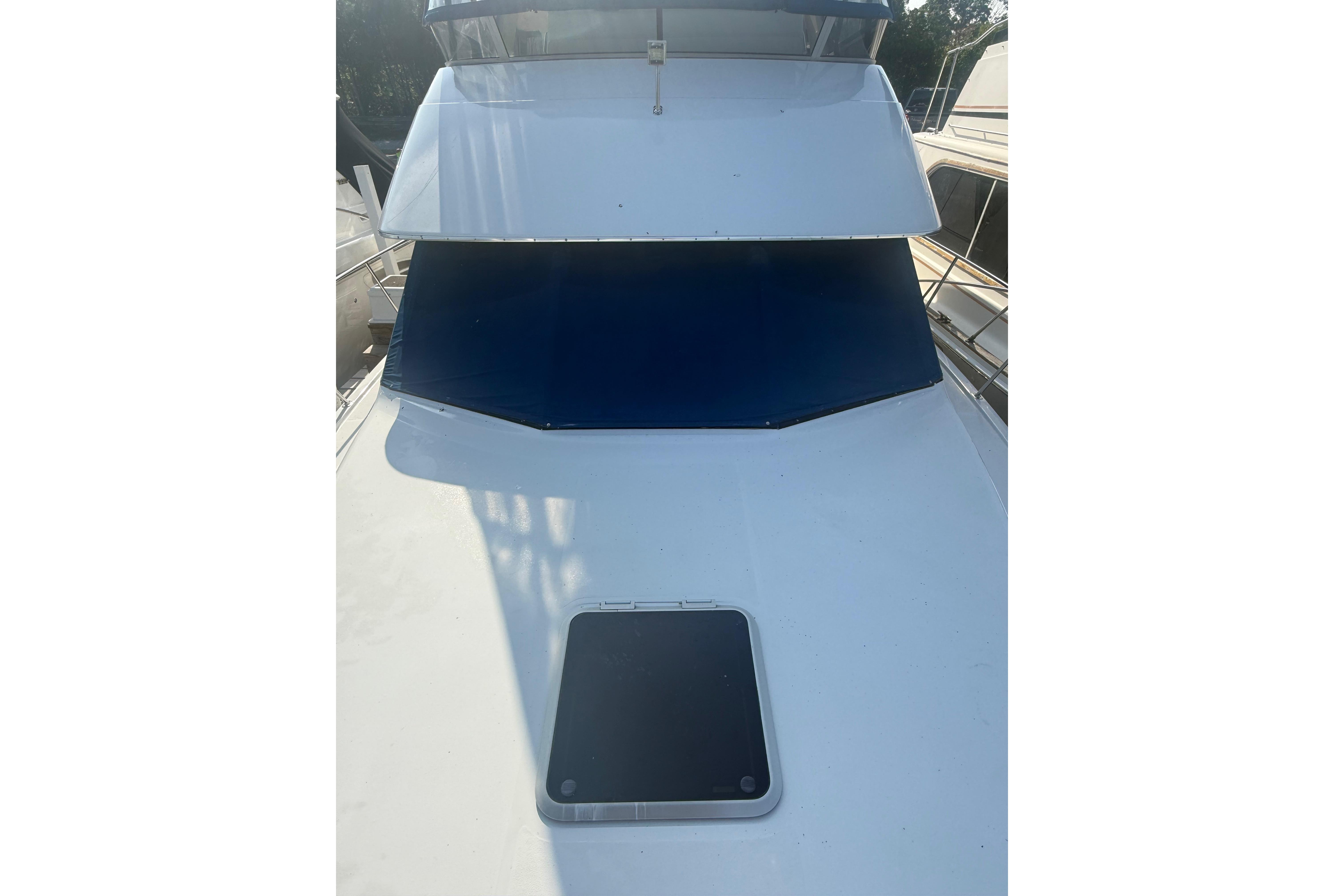 1992 Carver 33 Aft Cabin Motor Yacht with blue windshield cover and deck hatch.