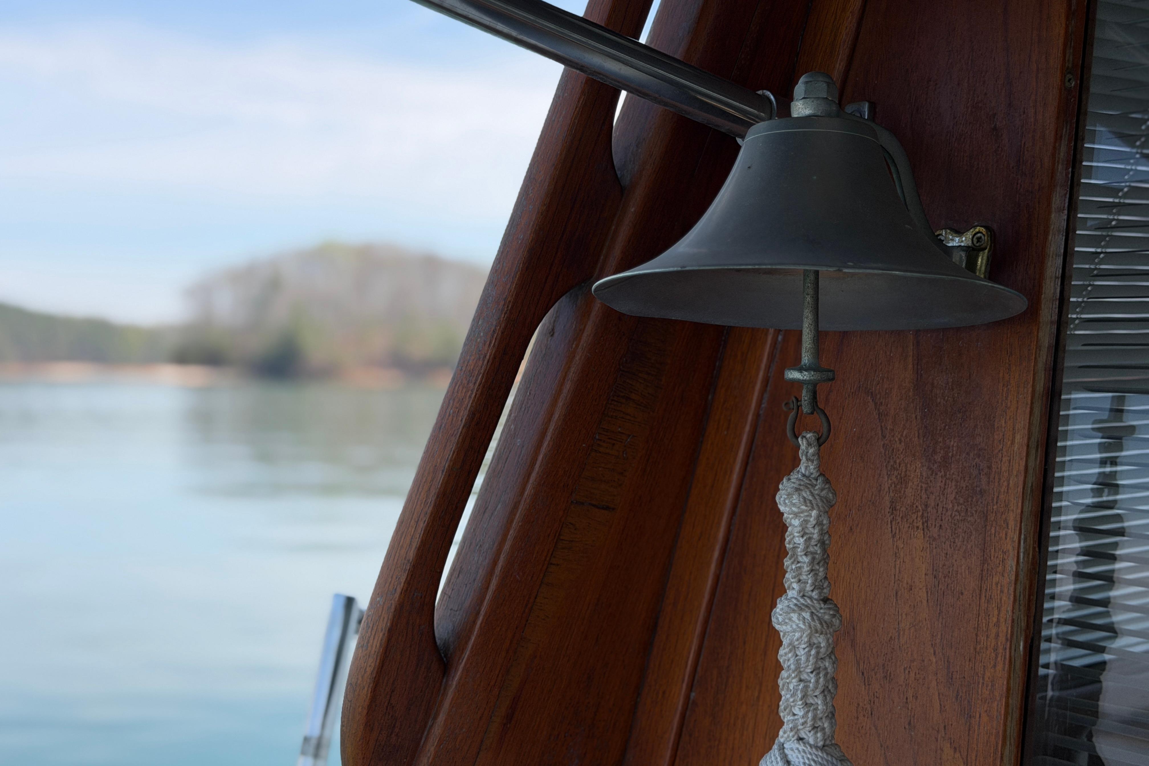 Bell on 1994 Bayliner 3888 MY Sedan boat, with serene water background.