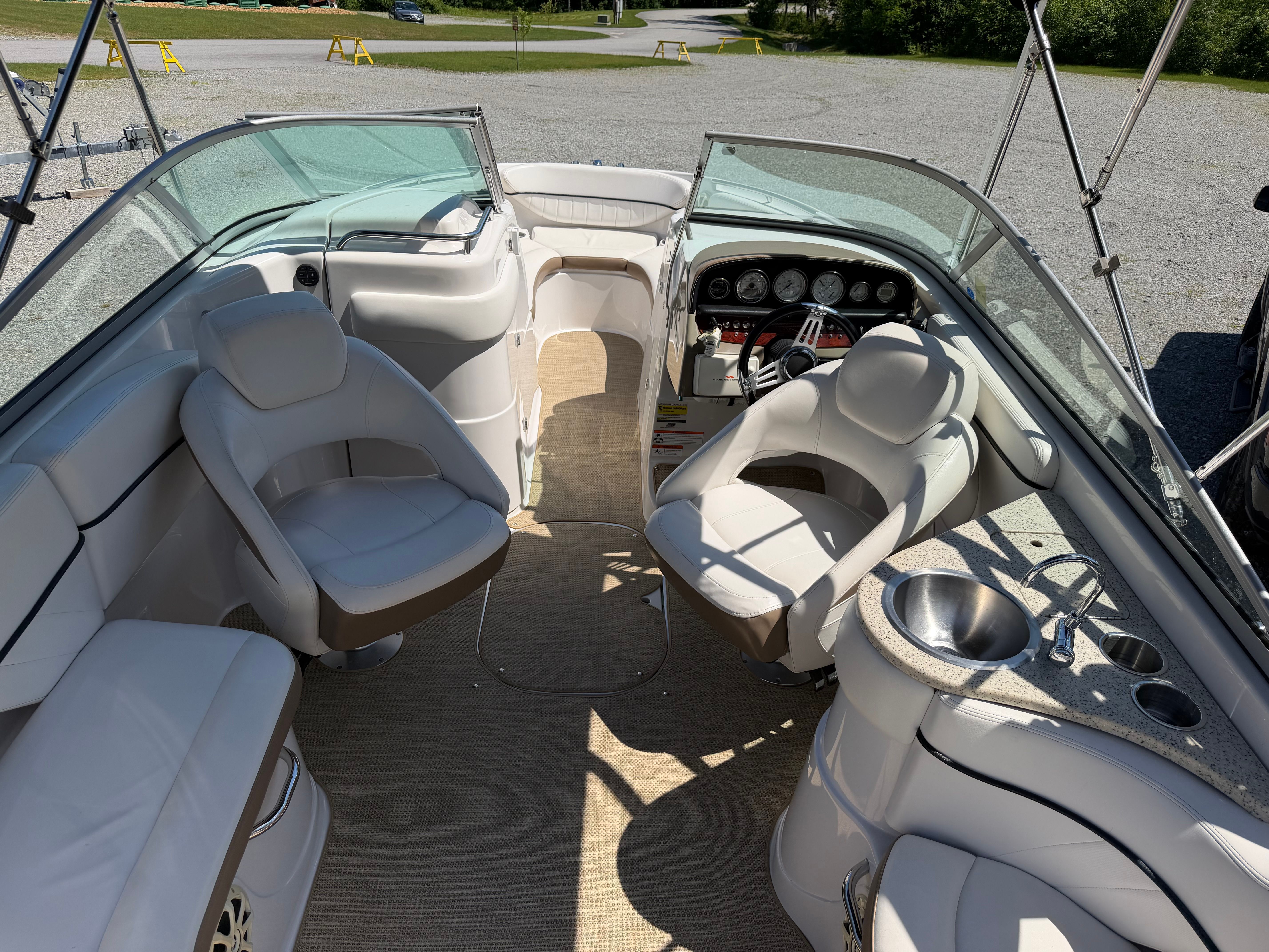 Interior view of a 2008 Four Winns H240 Frenzy with white seating and dashboard.