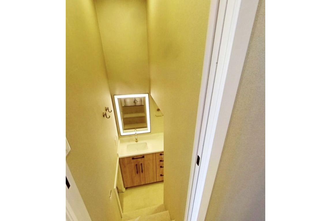 Narrow staircase leading to a modern bathroom with illuminated mirror, Adonia Galileo Trip 2023.