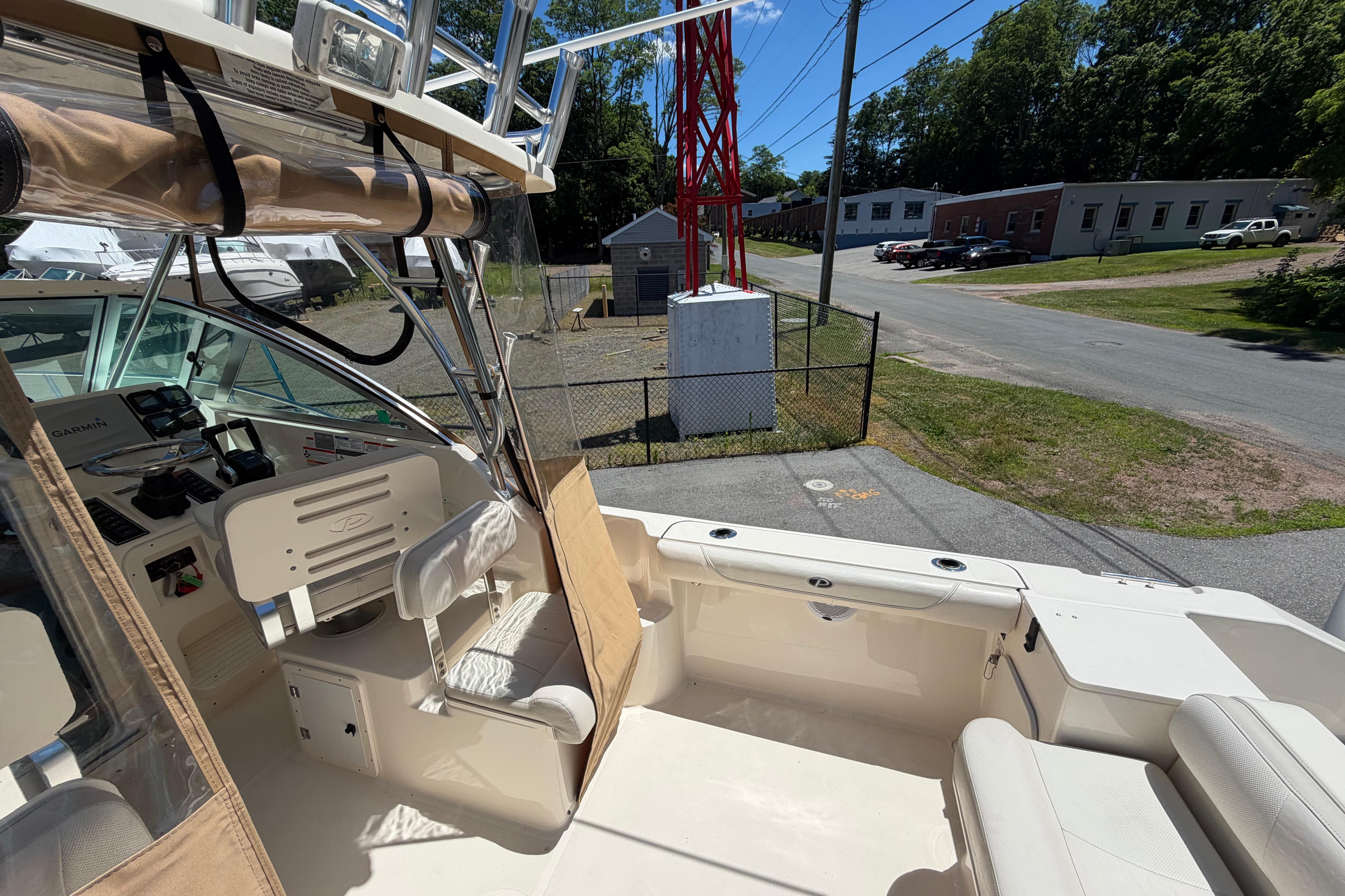 2010 Pursuit OS 255 Offshore boat interior with seating and control panel, parked outdoors.