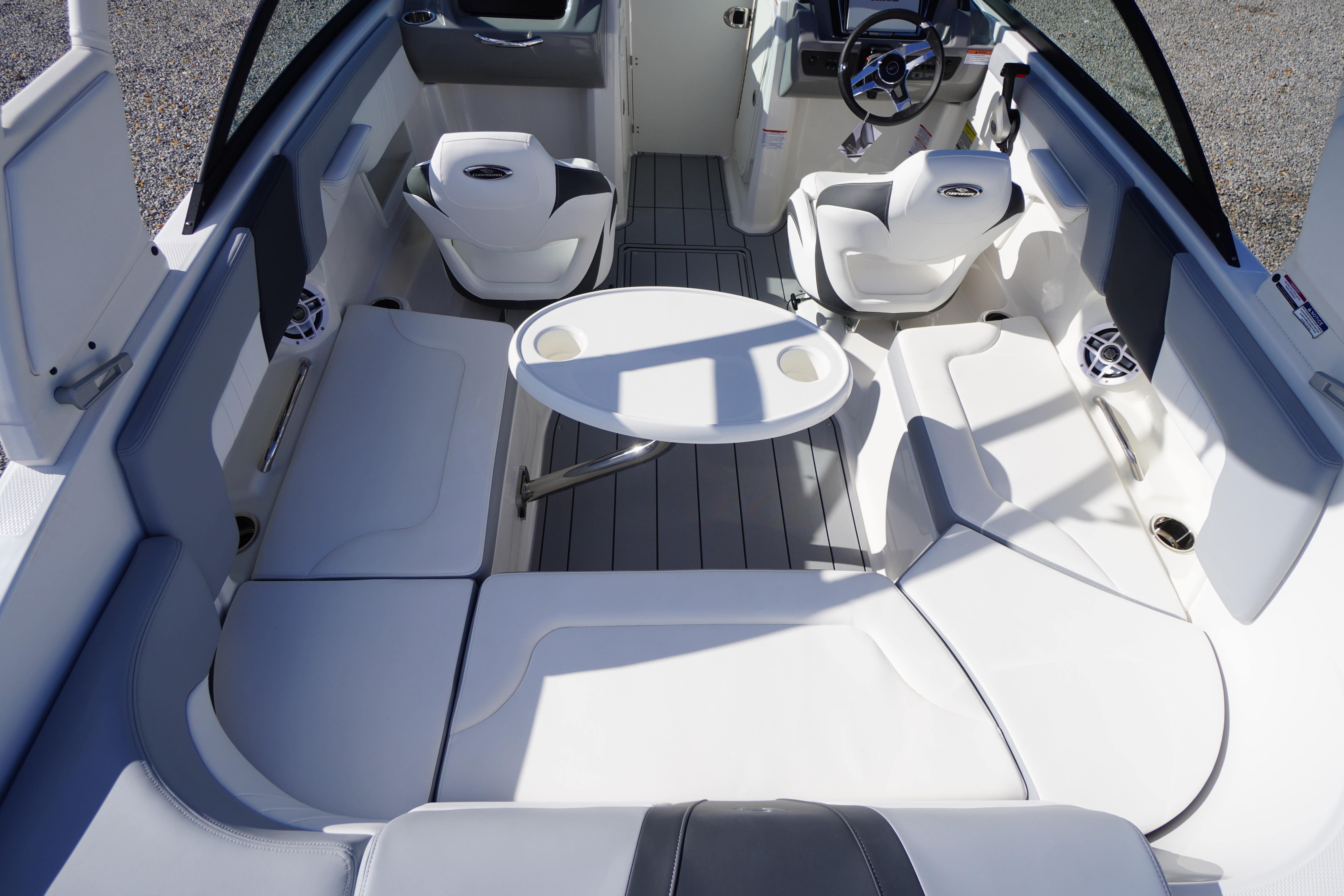 2026 Chaparral 23 SSi OB boat interior with seating and table, showcasing modern design.