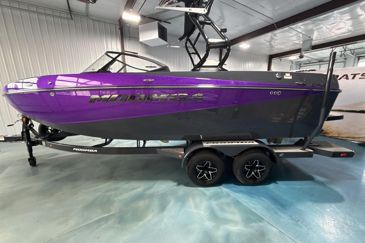 A purple 2026 Moomba Craz boat on a trailer inside a warehouse.