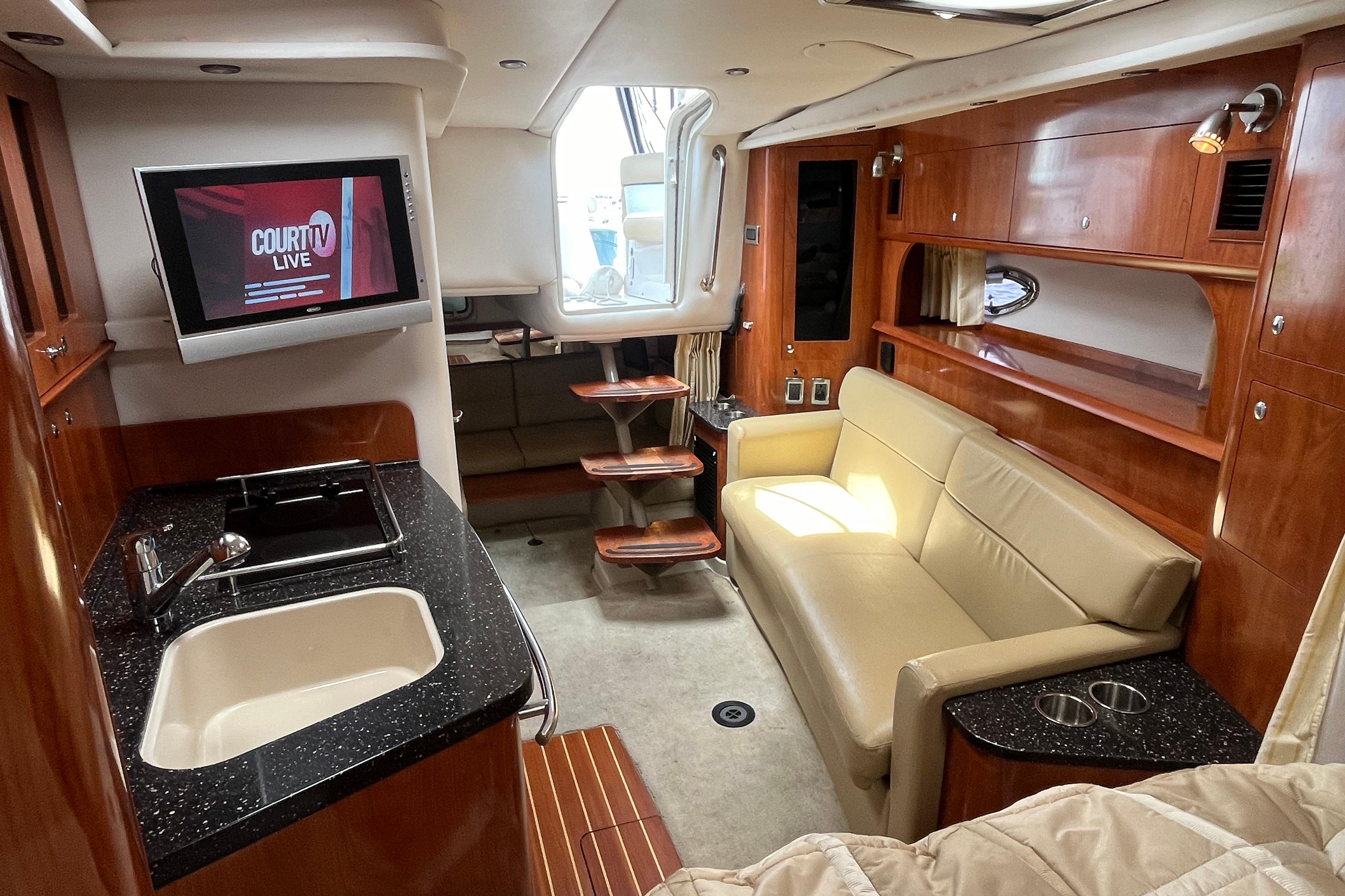 Luxurious 2008 Four Winns 338 Vista yacht interior with kitchenette, sofa, and TV.
