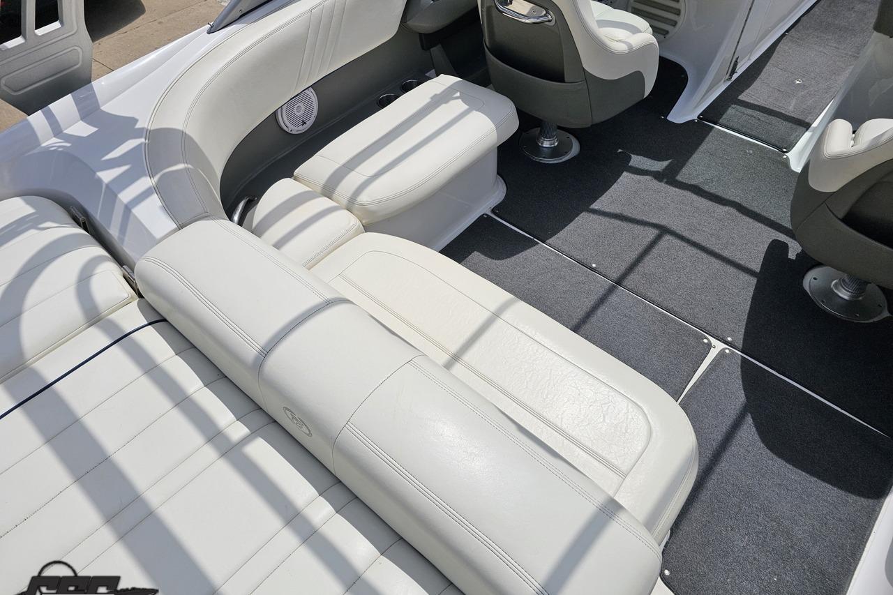 Interior of a 2010 Cobalt 232 WSS boat with white leather seating and gray carpet.