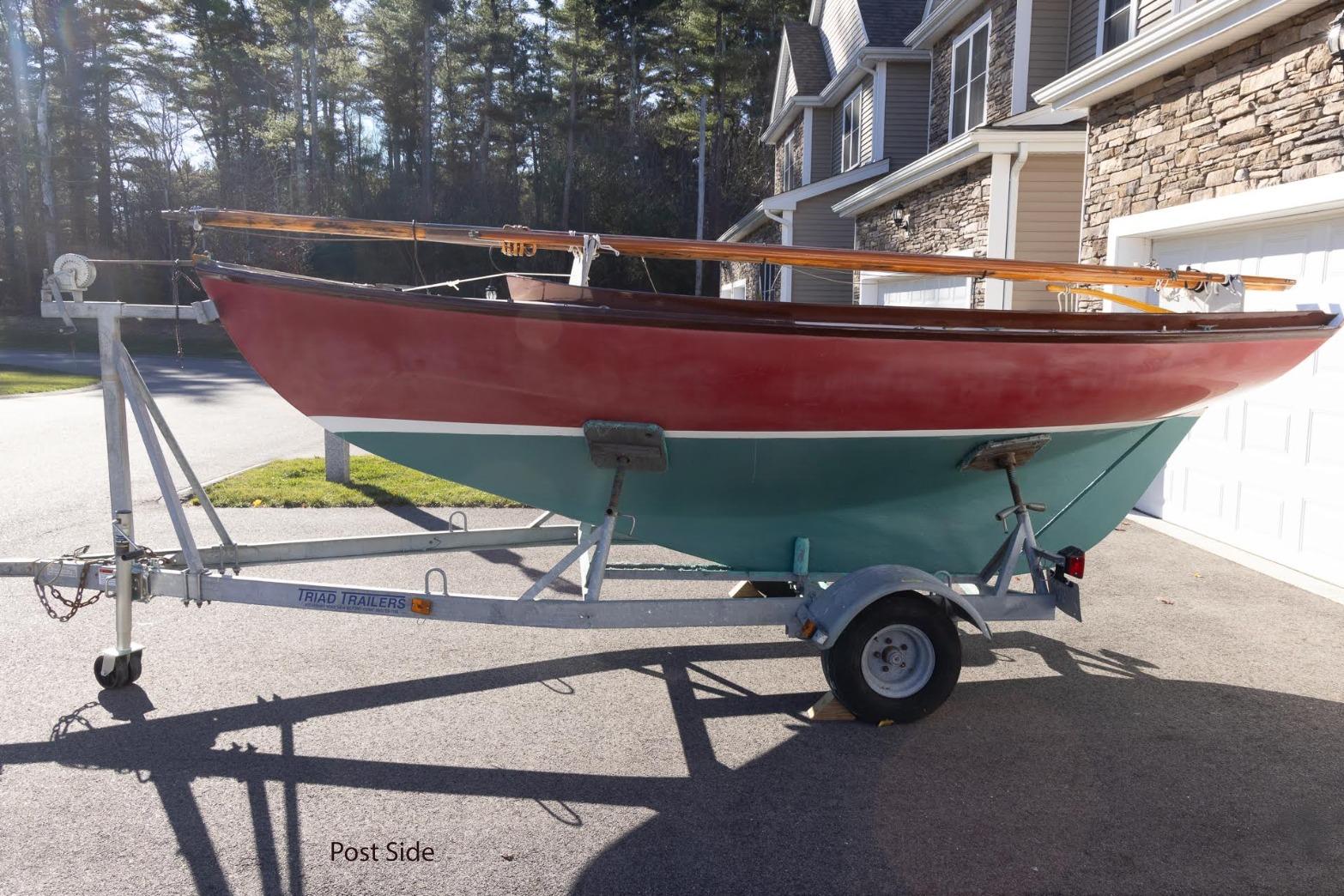Red and teal Herreshoff 12 sailboat on trailer, Cape Cod Shipbuilding, 2002 model.