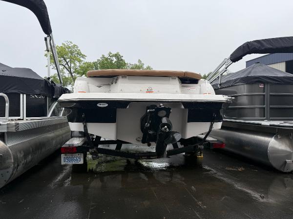 2017 Glastron 205 boat on trailer, parked between pontoons, rear view.