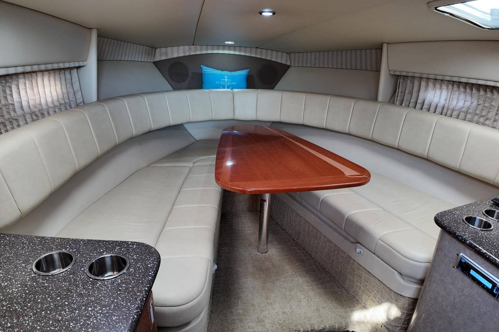 2007 Formula 330 Sun Sport cabin interior with beige seating and wooden table.