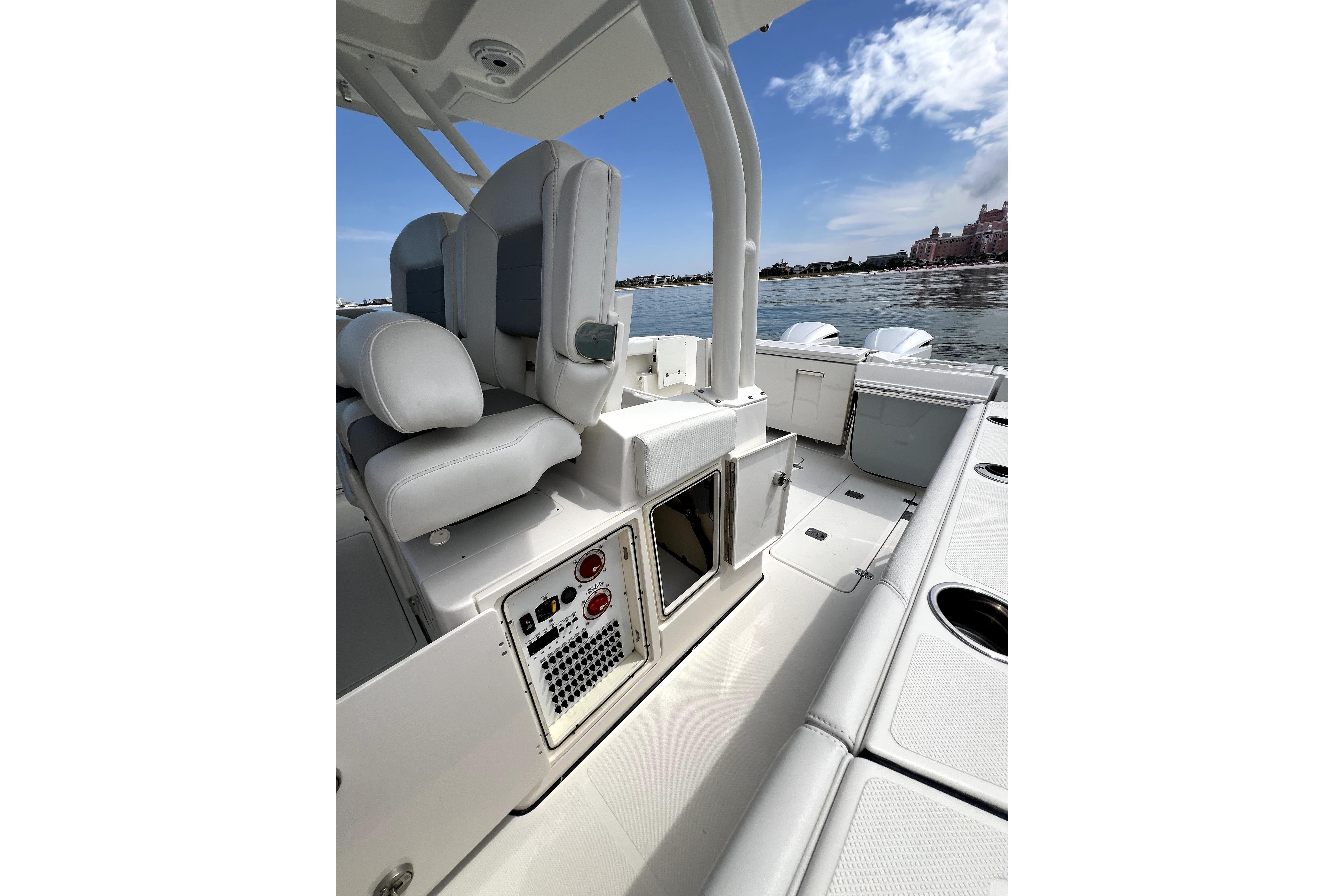 2020 Pursuit S 328 Sport boat interior with seating and control panel, docked by calm waters.